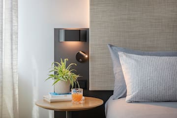 a table with a plant on it next to a bed