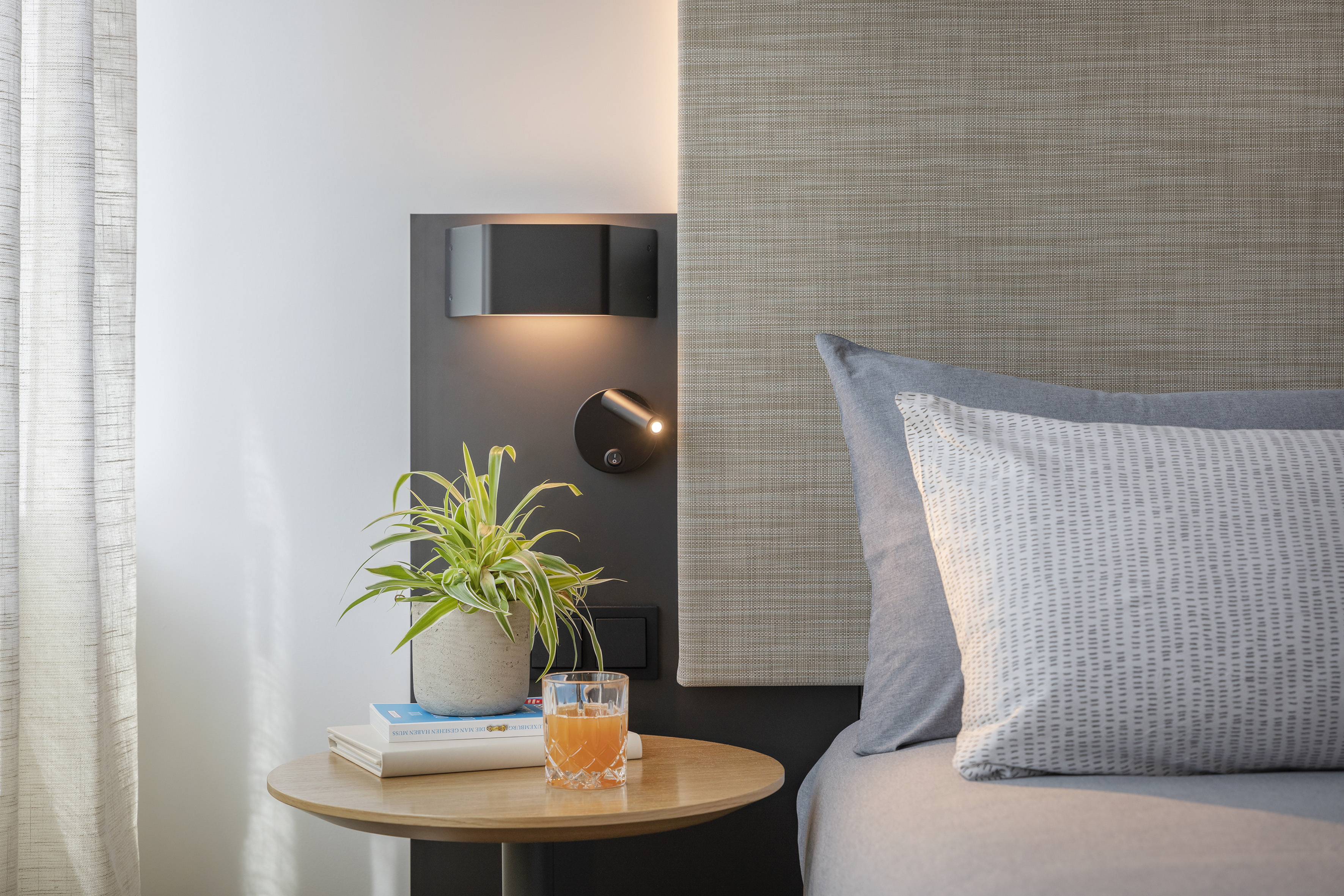 a table with a plant on it next to a bed