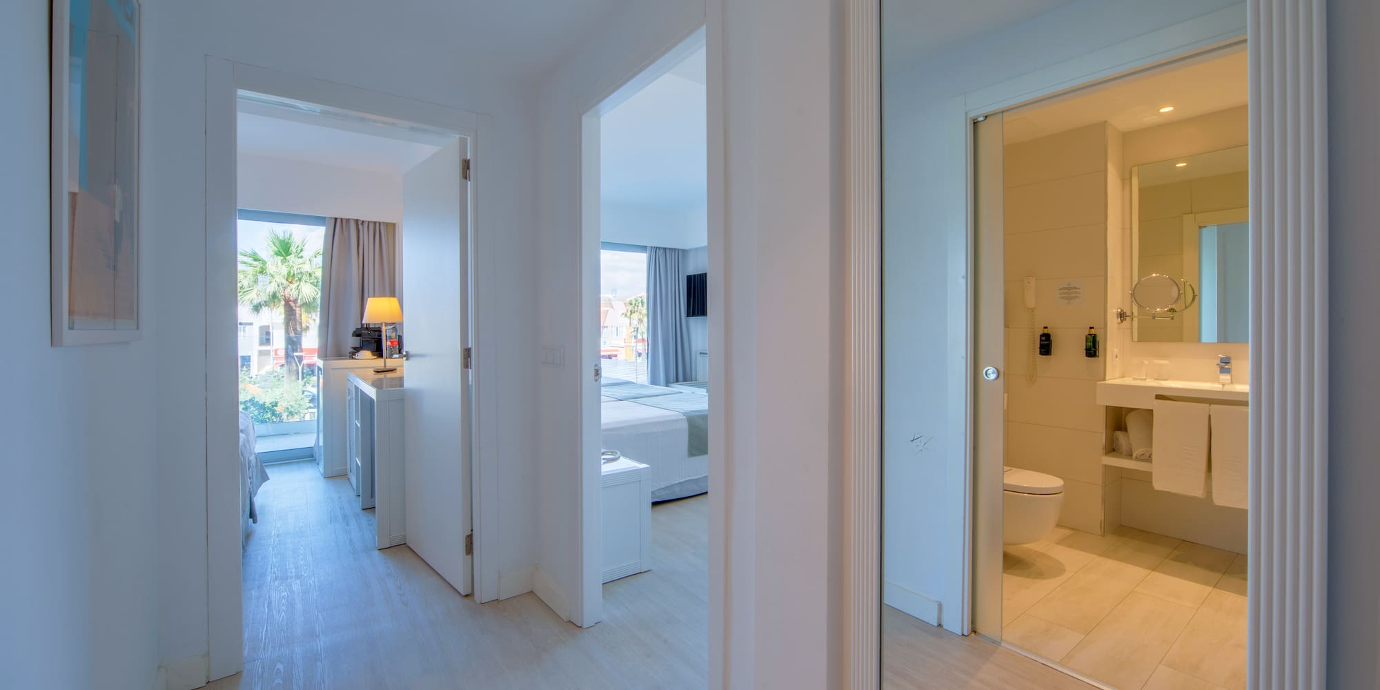 a hallway with a mirror and a toilet