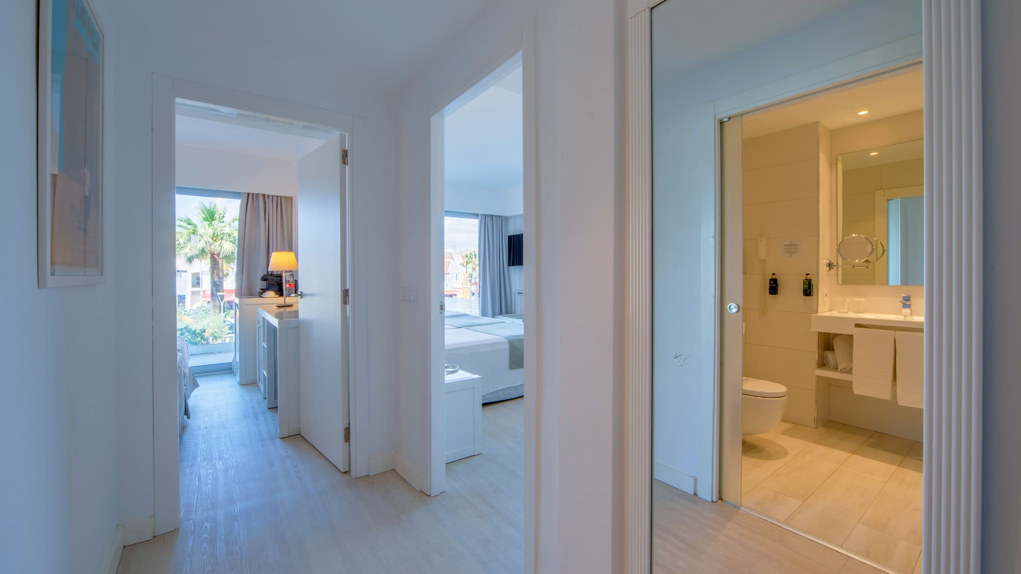 a hallway with a mirror and a toilet