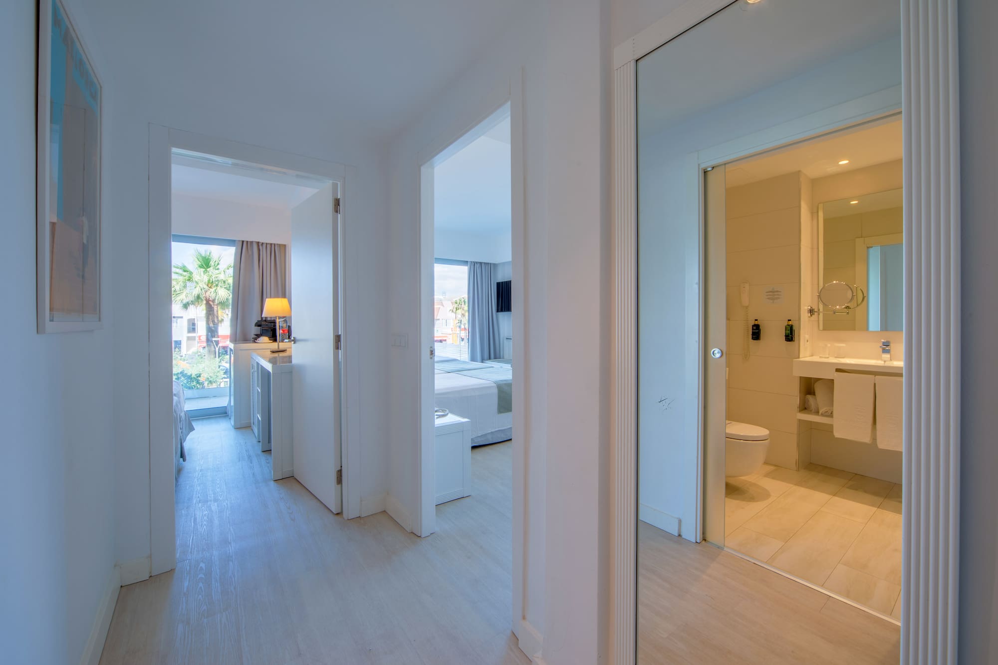 a hallway with a mirror and a toilet