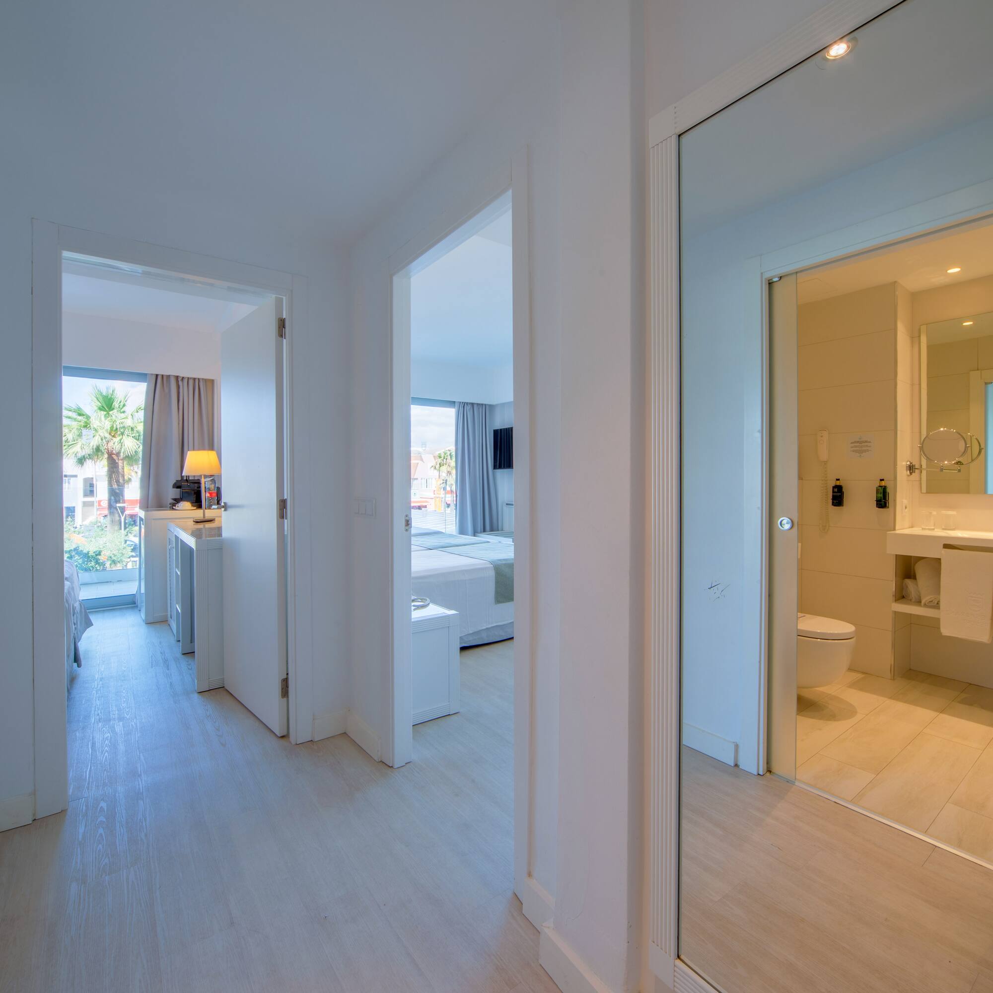 a hallway with a mirror and a toilet