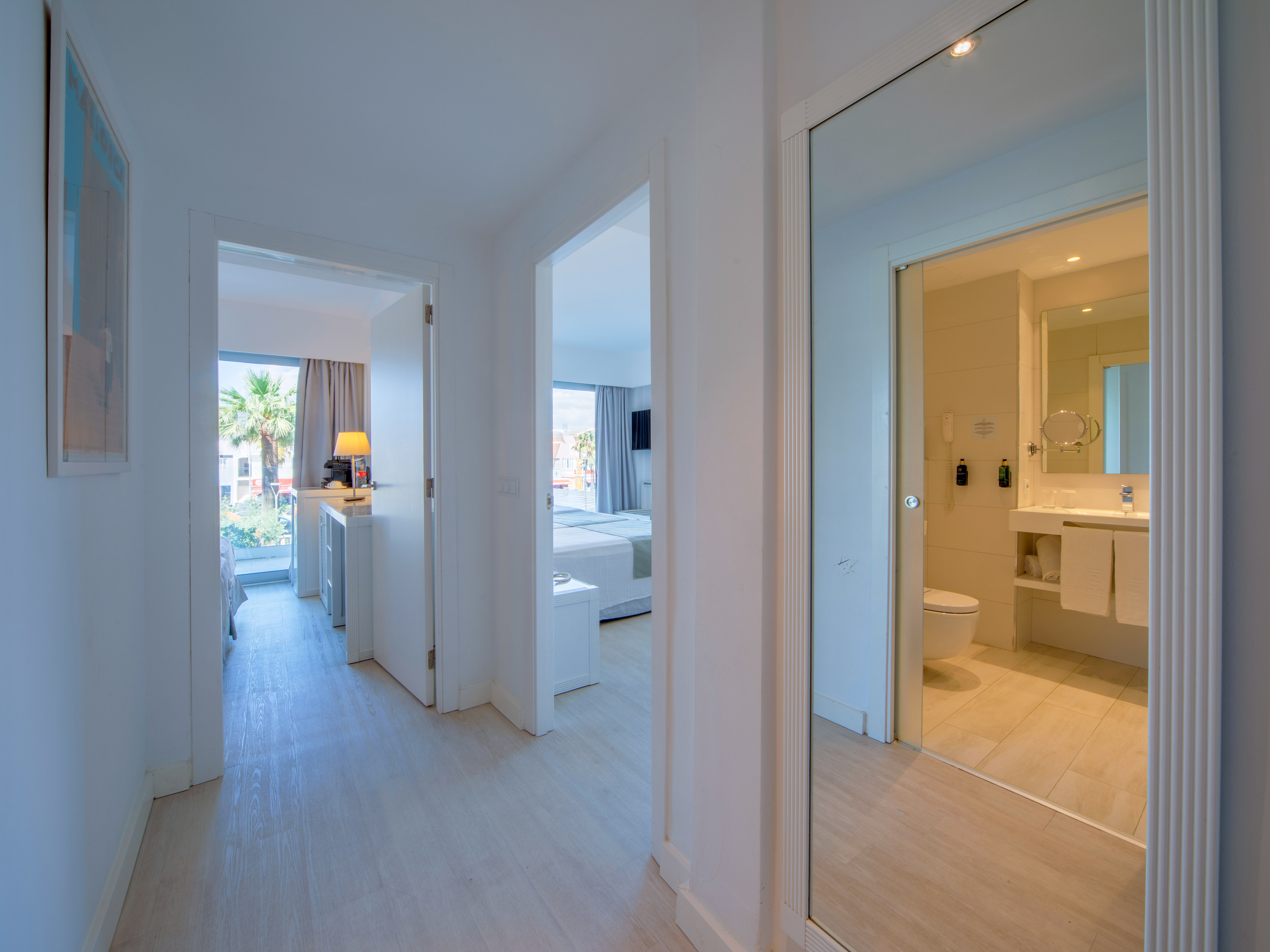 a hallway with a mirror and a toilet