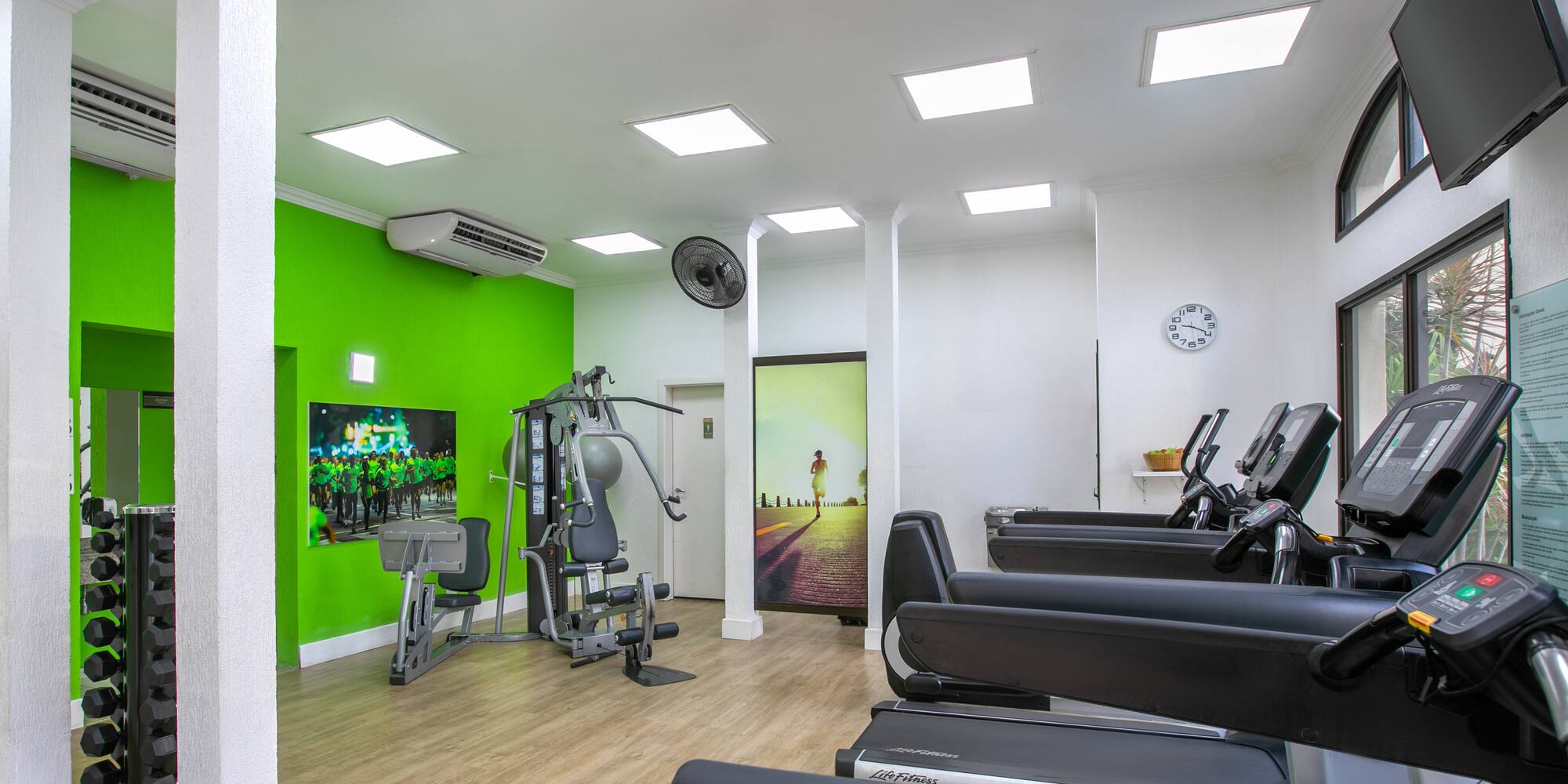 a room with exercise equipment and a green wall