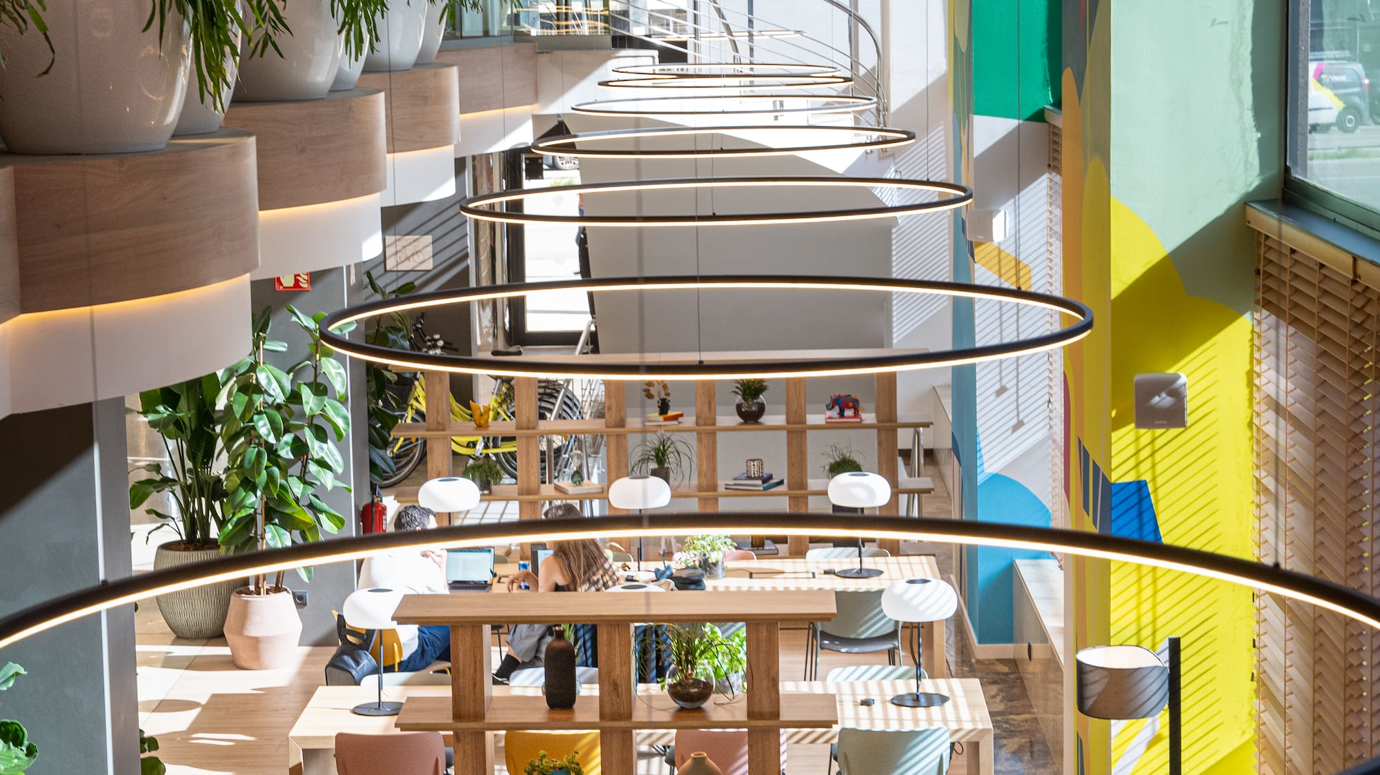 a room with a spiral staircase and tables and chairs