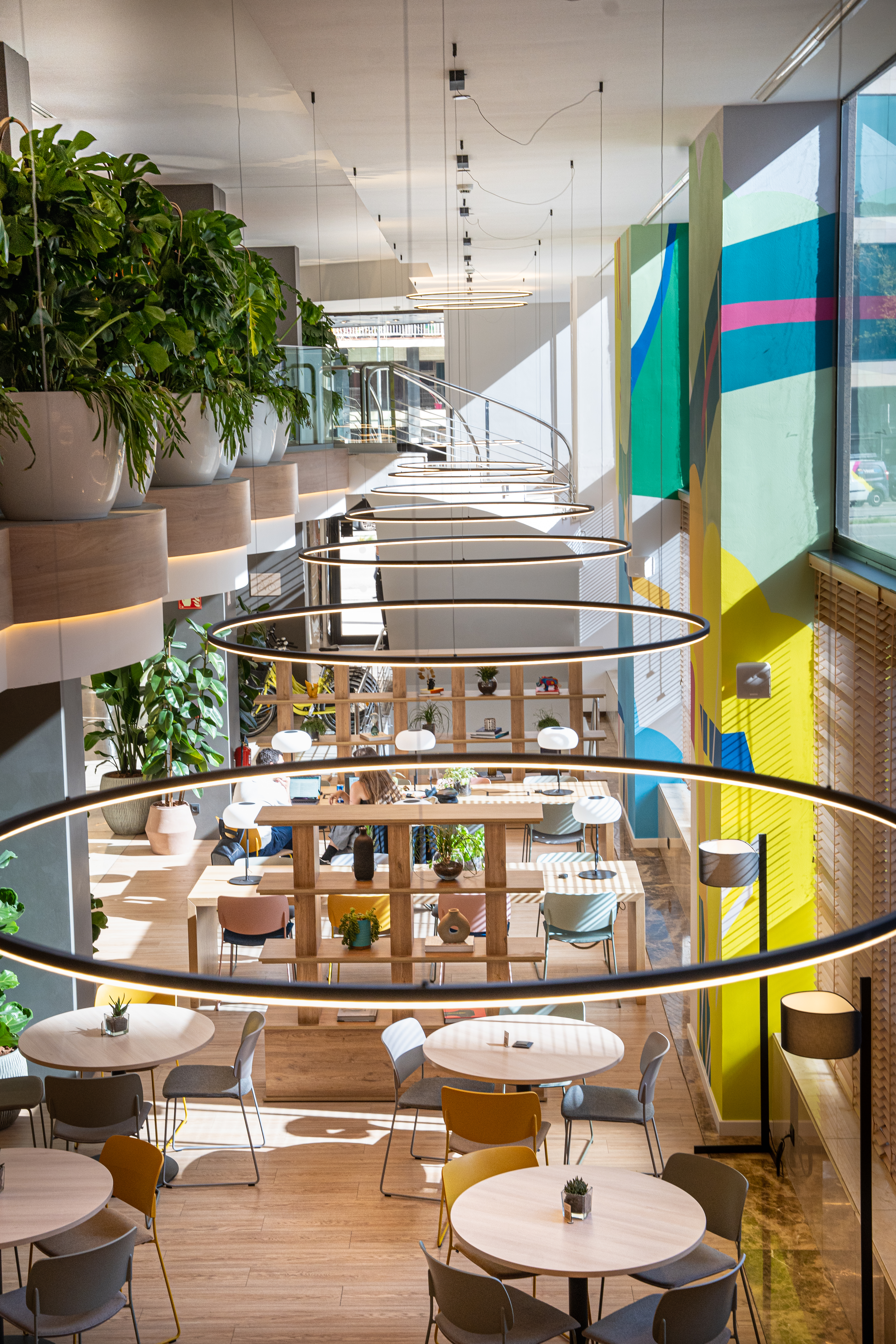 a room with a spiral staircase and tables and chairs