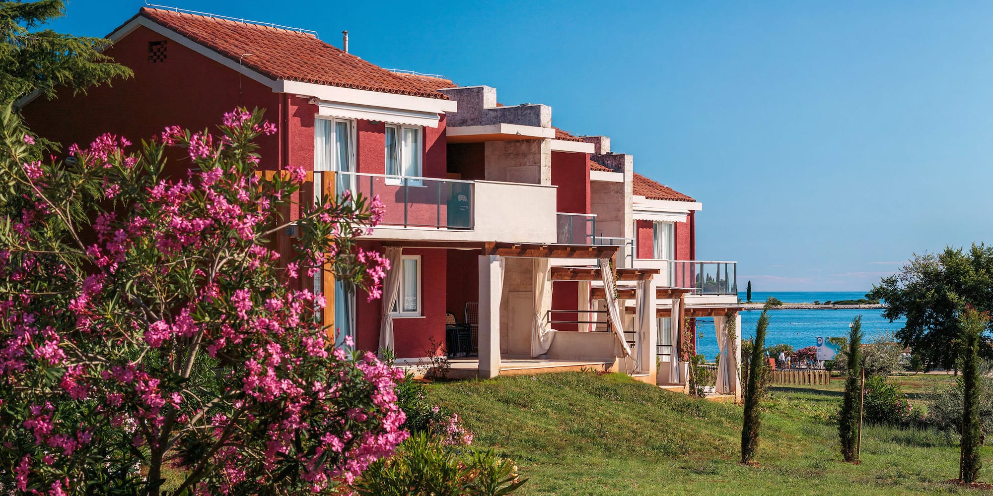 a row of houses with a beach and water in the background