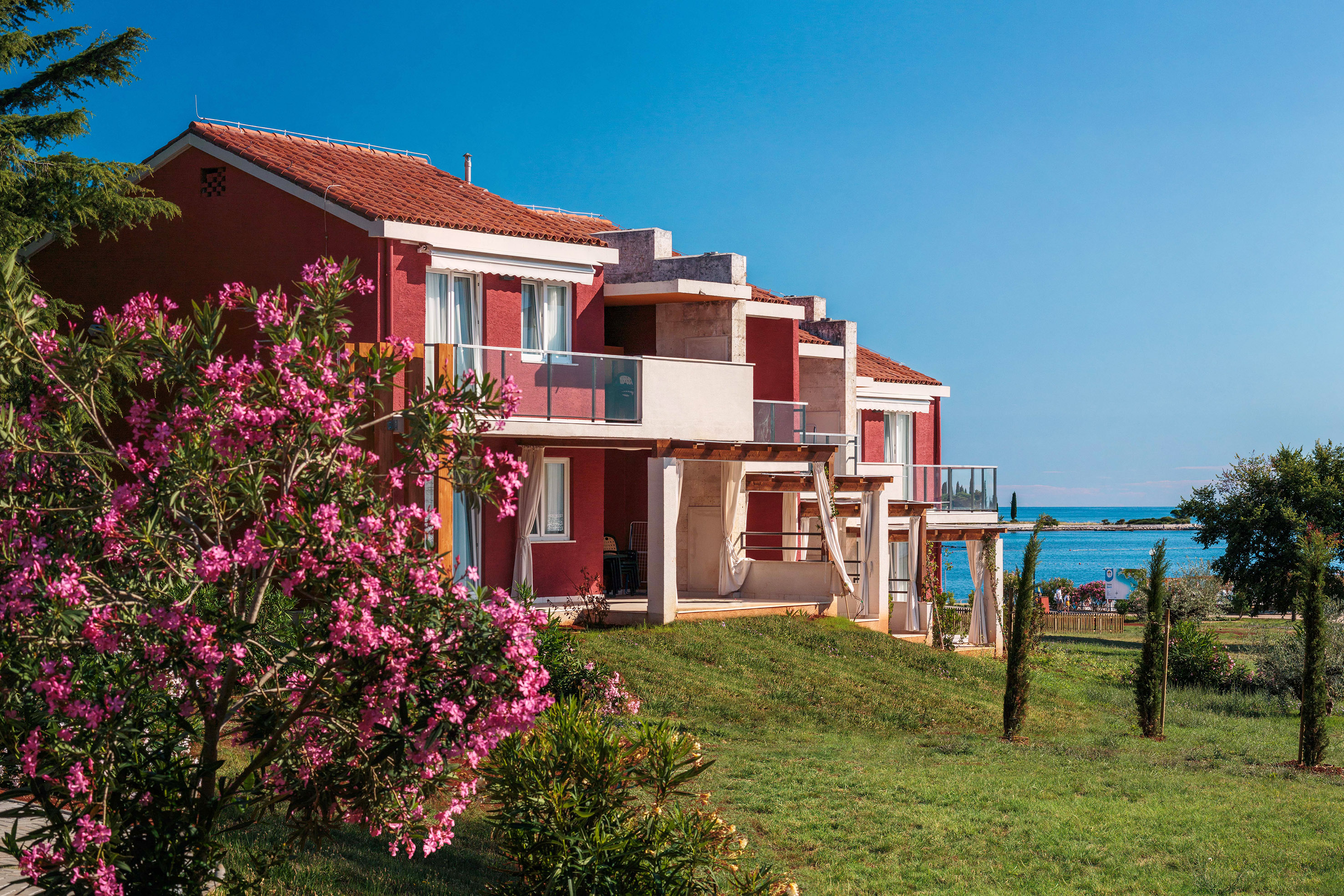 a row of houses with a beach and water in the background