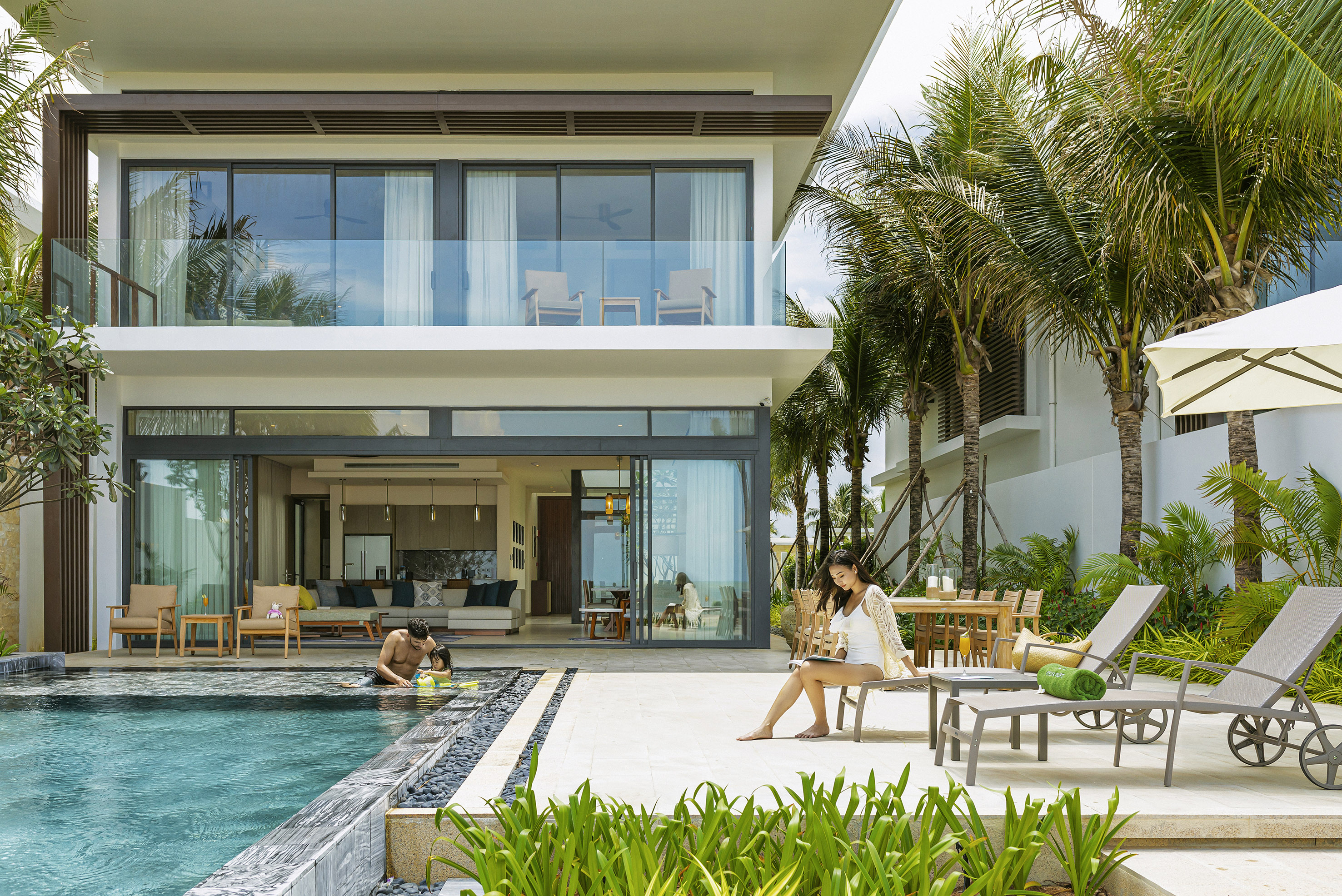 Luxury villa private pool, family relaxing at tropical resort.