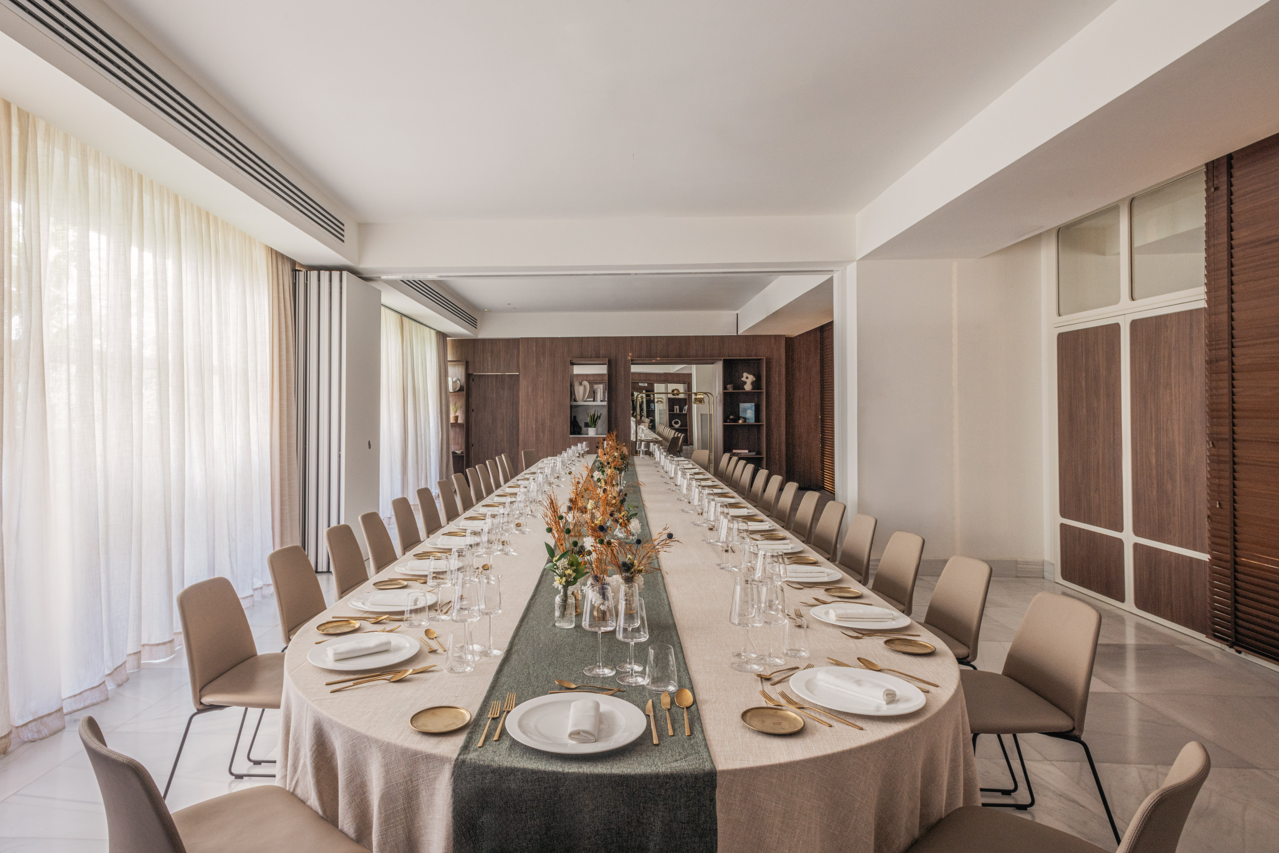 Modern long dining table set for a conference or elegant private event.