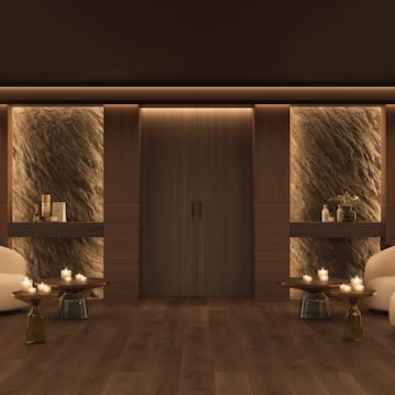 a room with a couple of chairs and a table with candles