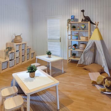 a room with a teepee and tables and chairs