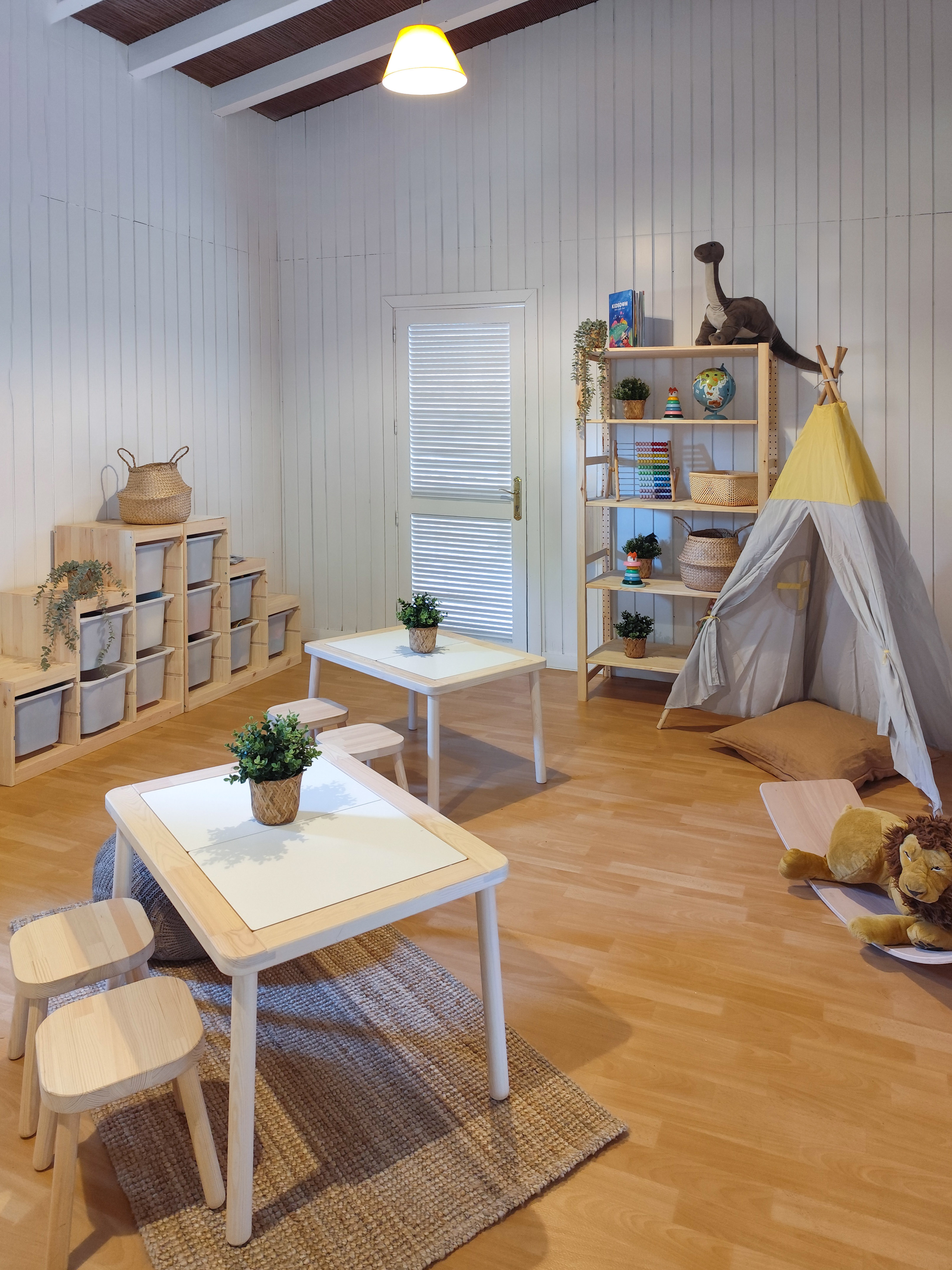 a room with a teepee and tables and chairs