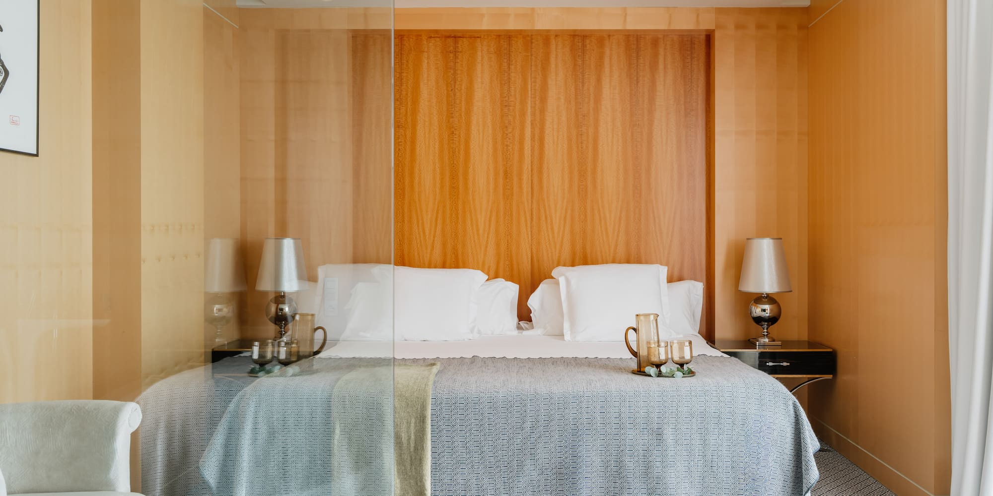 a bed with a glass wall behind it