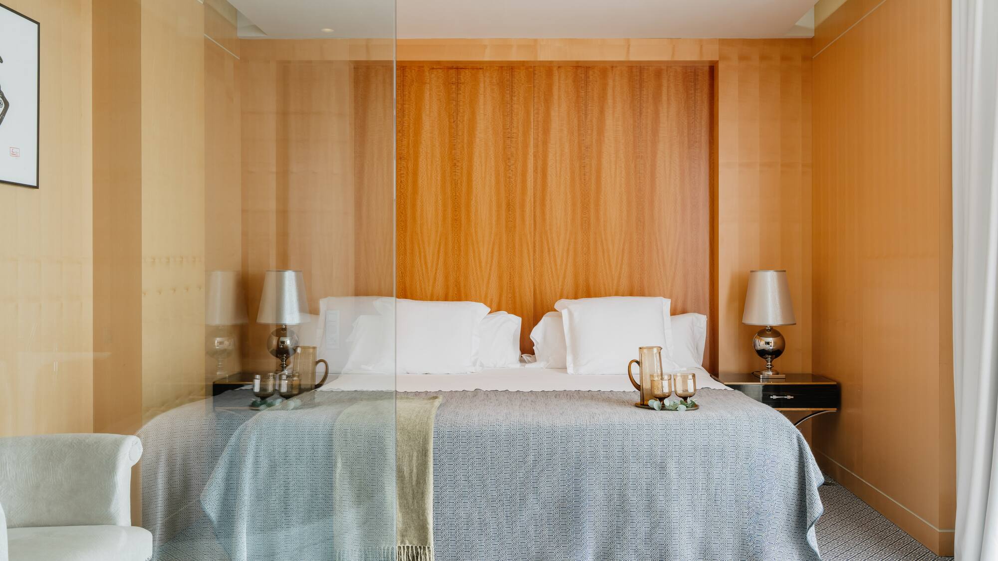 a bed with a glass wall behind it