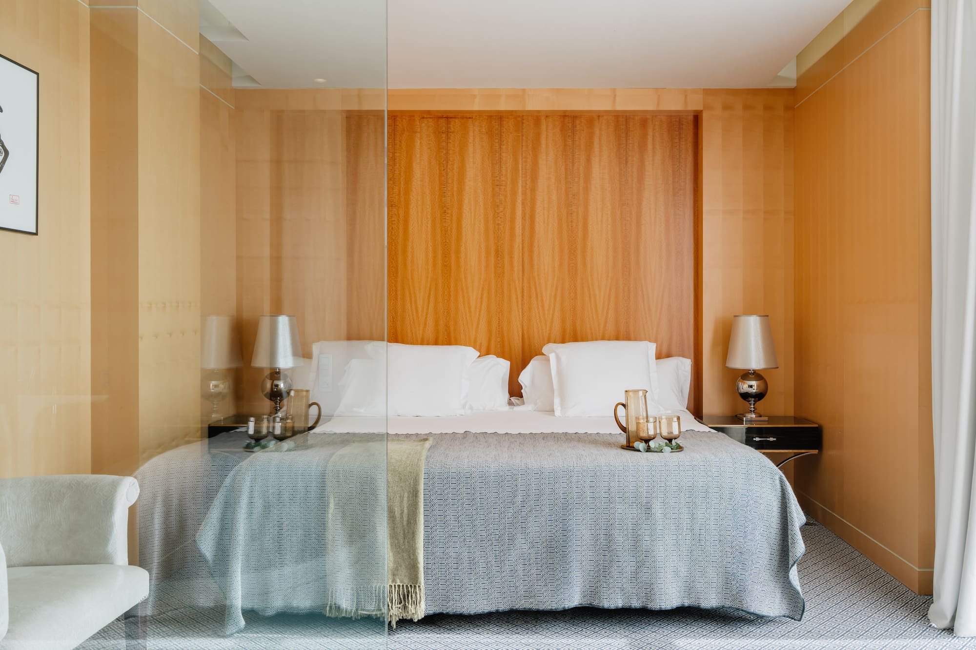 a bed with a glass wall behind it