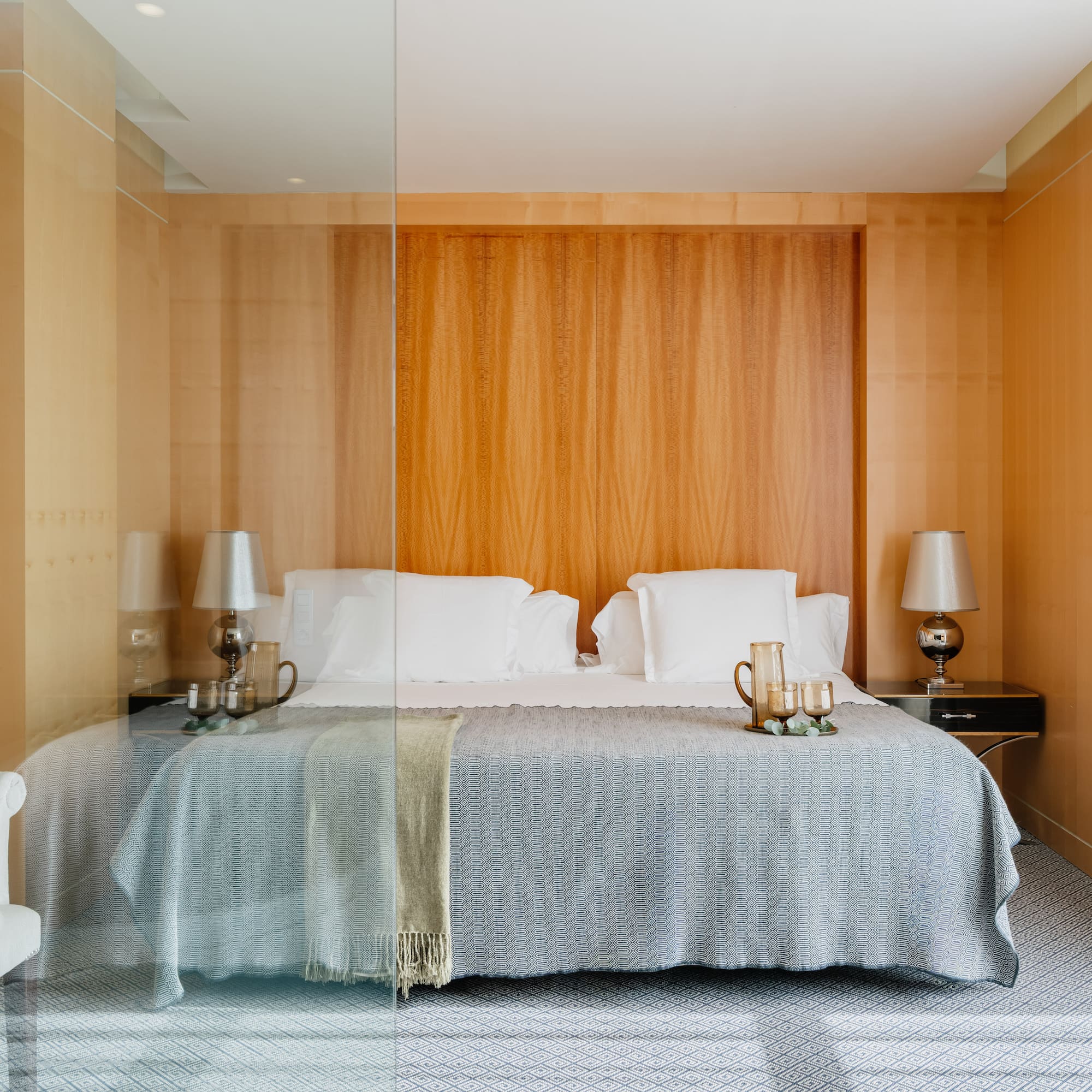 a bed with a glass wall behind it