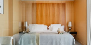 a bed with a glass wall behind it