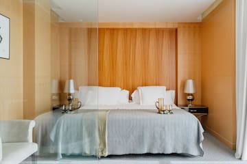 a bed with a glass wall behind it