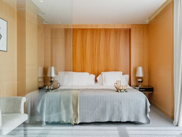 a bed with a glass wall behind it