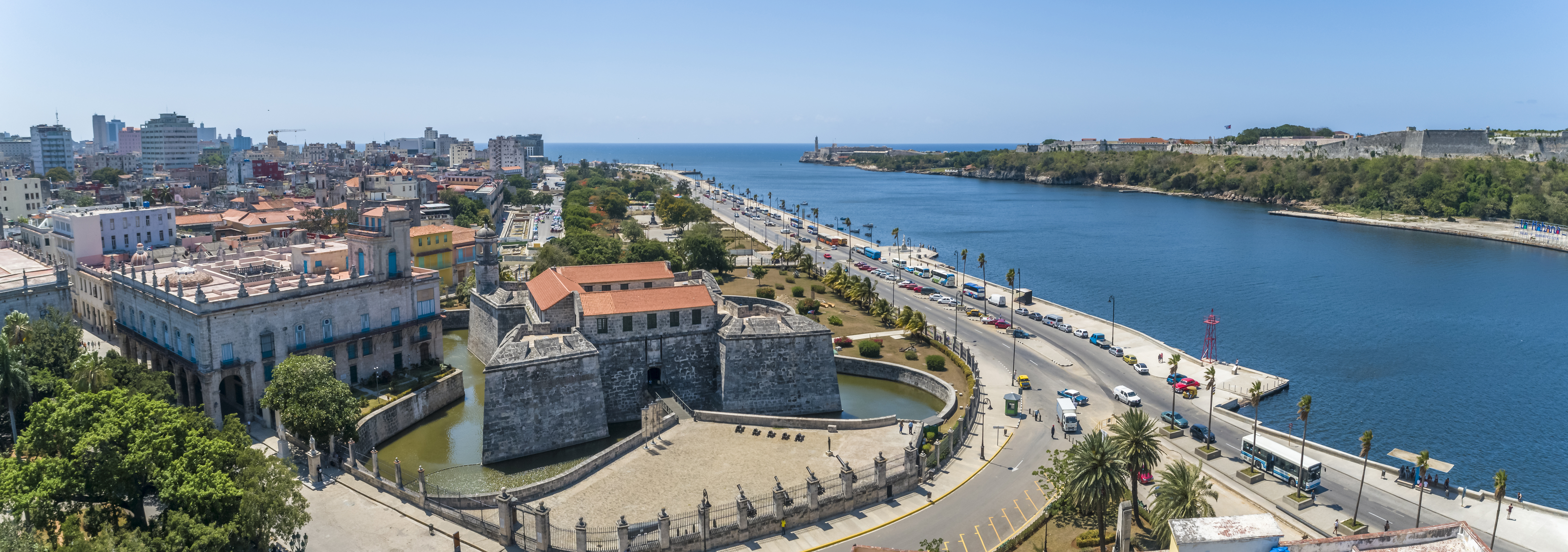 a large stone building next to a body of water