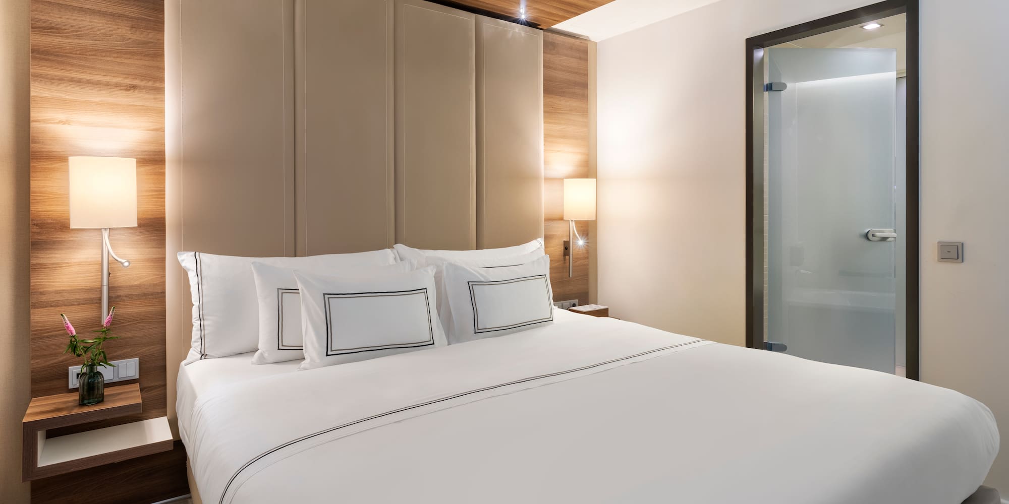 a bed with white sheets and a wood paneled headboard