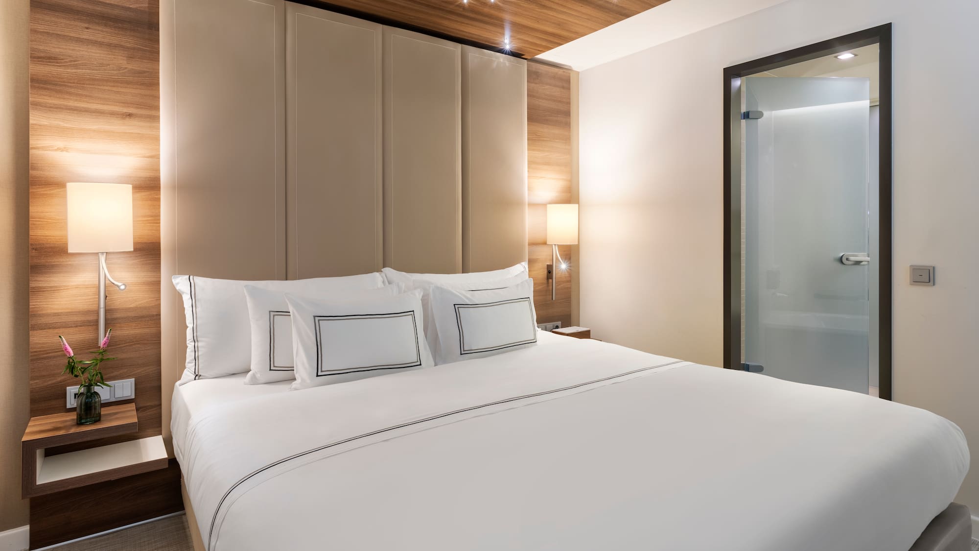 a bed with white sheets and a wood paneled headboard