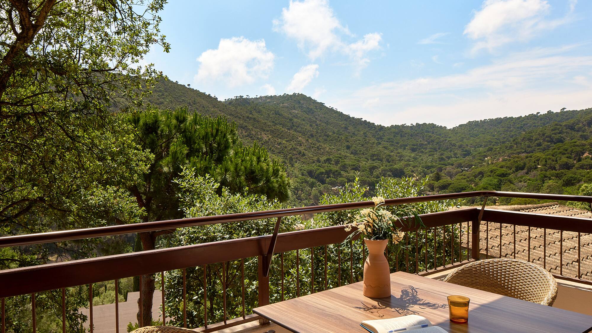 a table with a book and a book on a balcony overlooking a valley