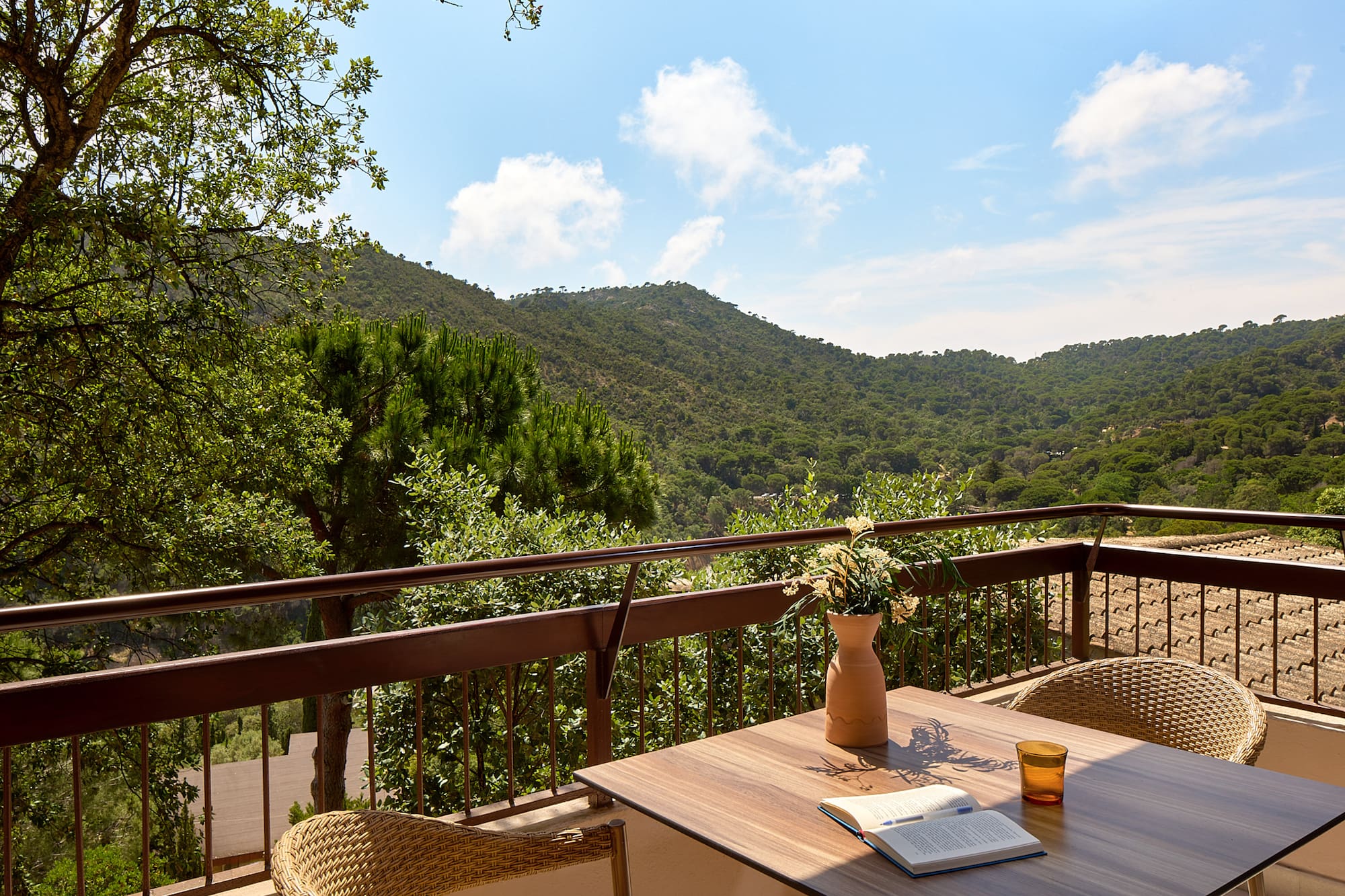 a table with a book and a book on a balcony overlooking a valley