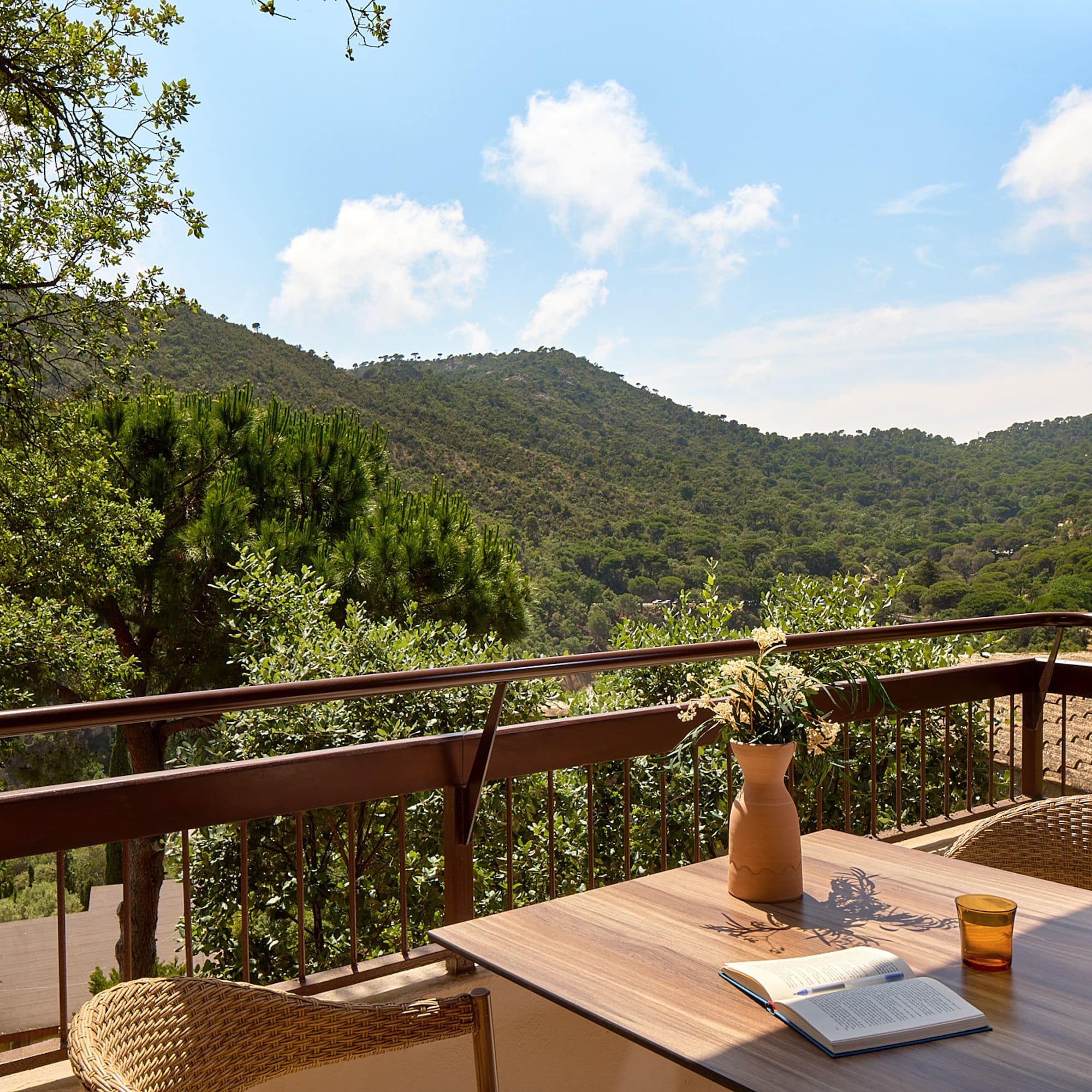 a table with a book and a book on a balcony overlooking a valley
