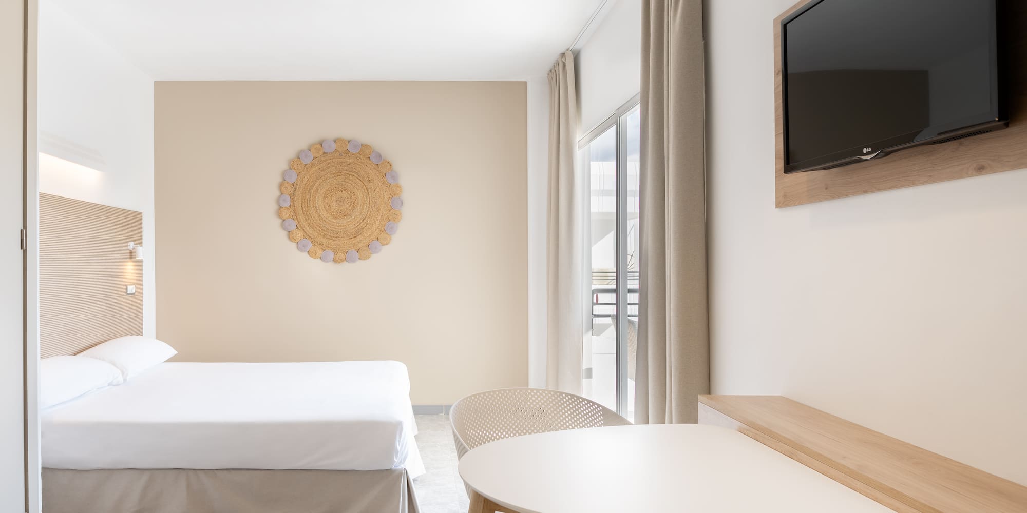 a room with a bed and a table and a television