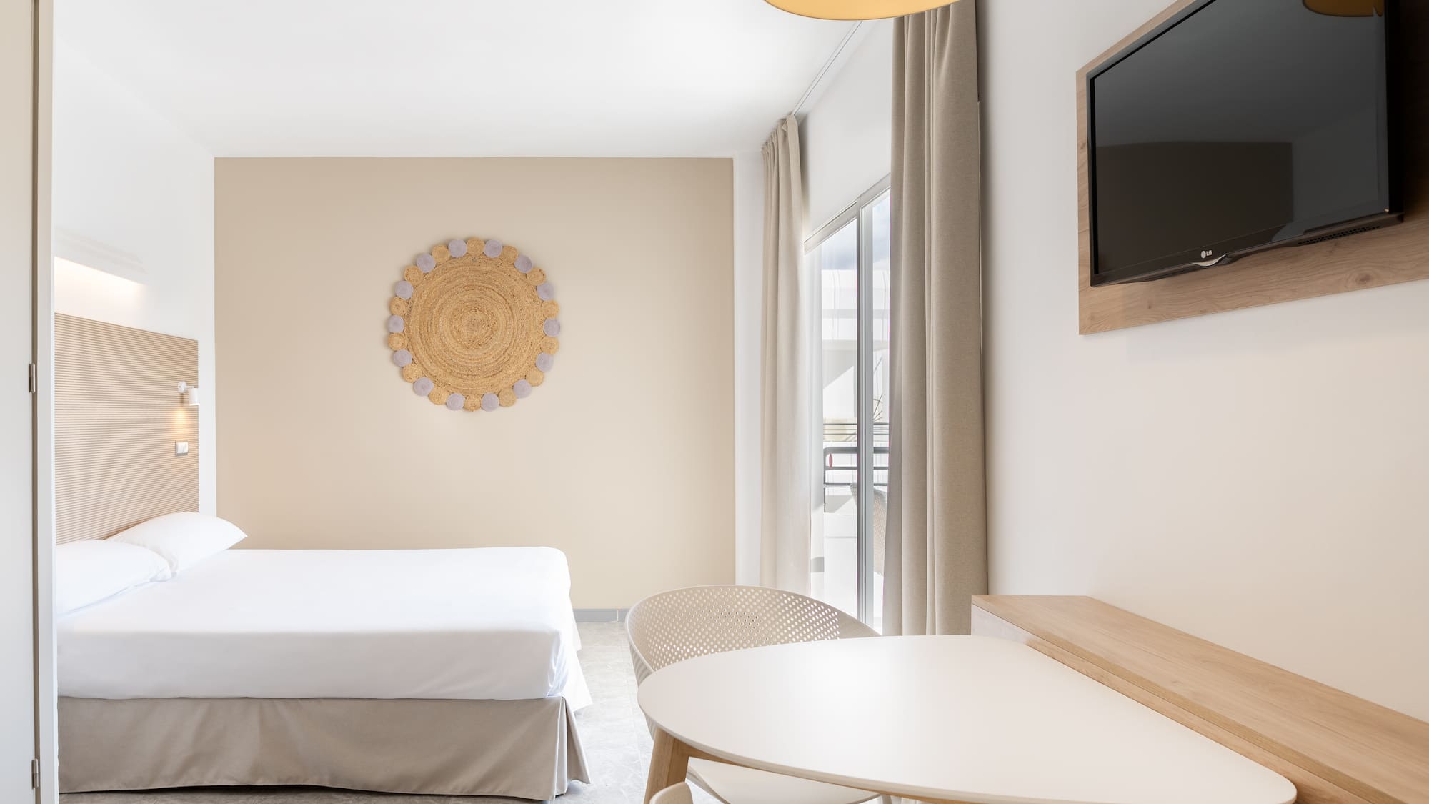 a room with a bed and a table and a television