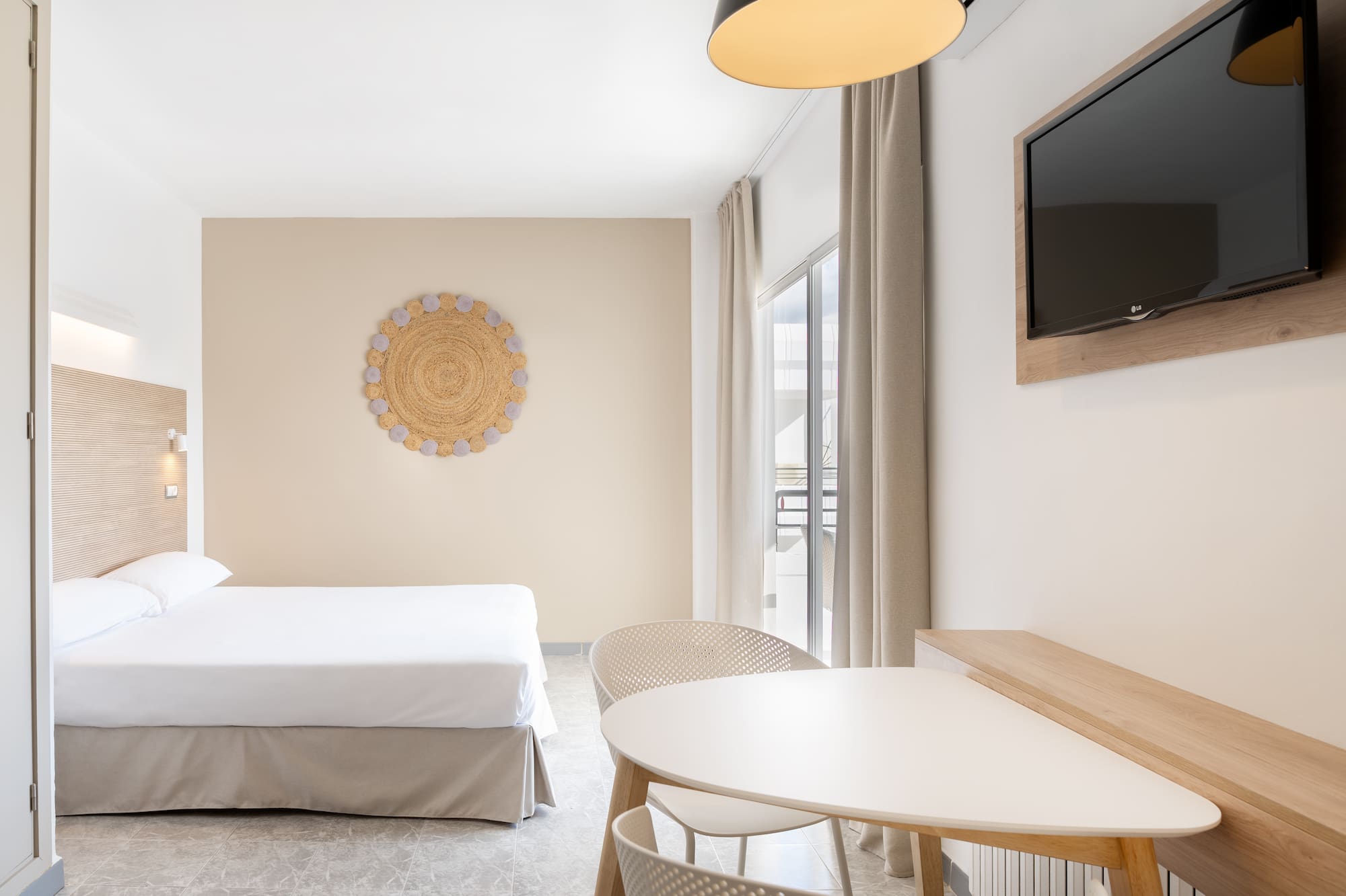 a room with a bed and a table and a television