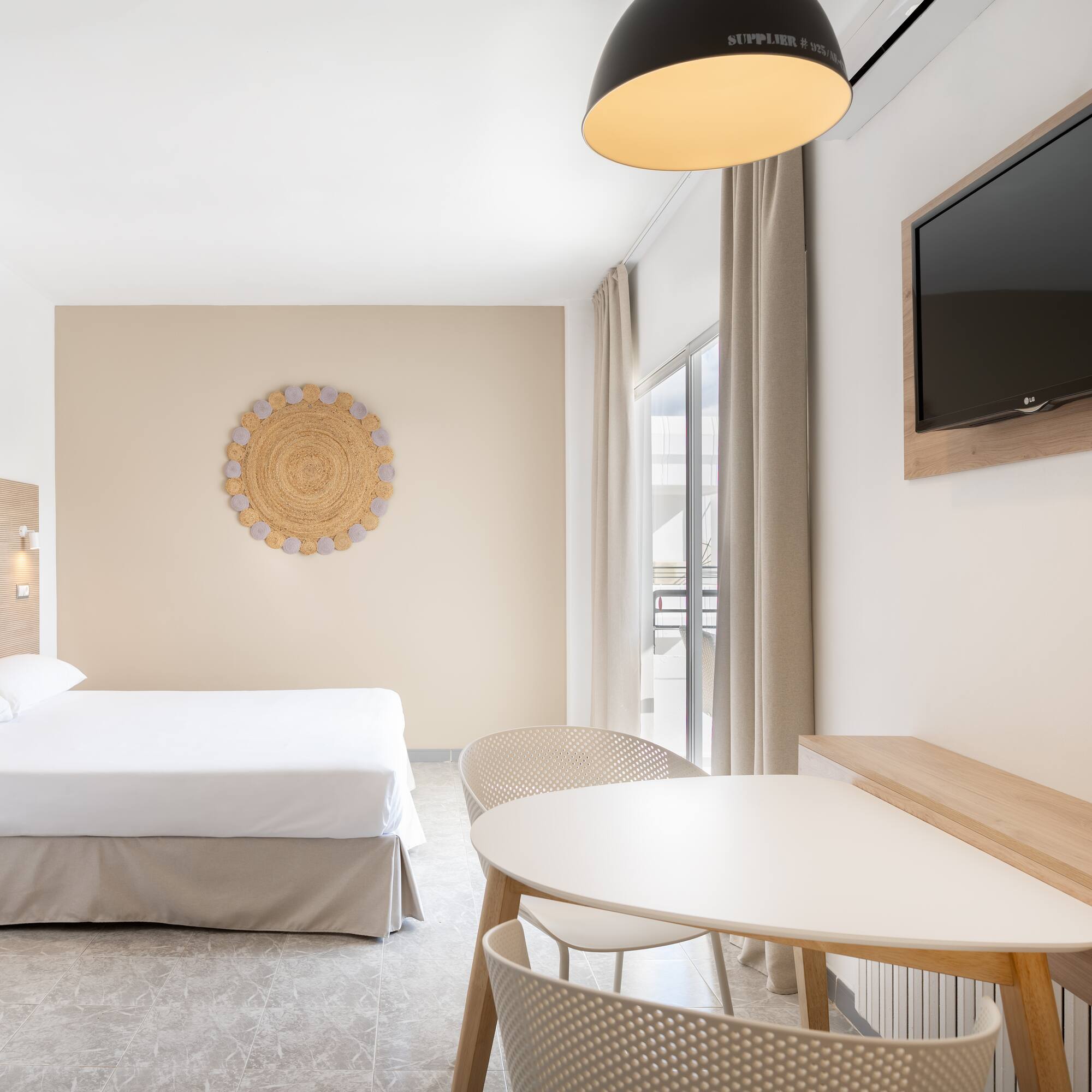 a room with a bed and a table and a television