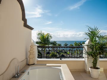 a bathtub on a balcony overlooking the ocean
