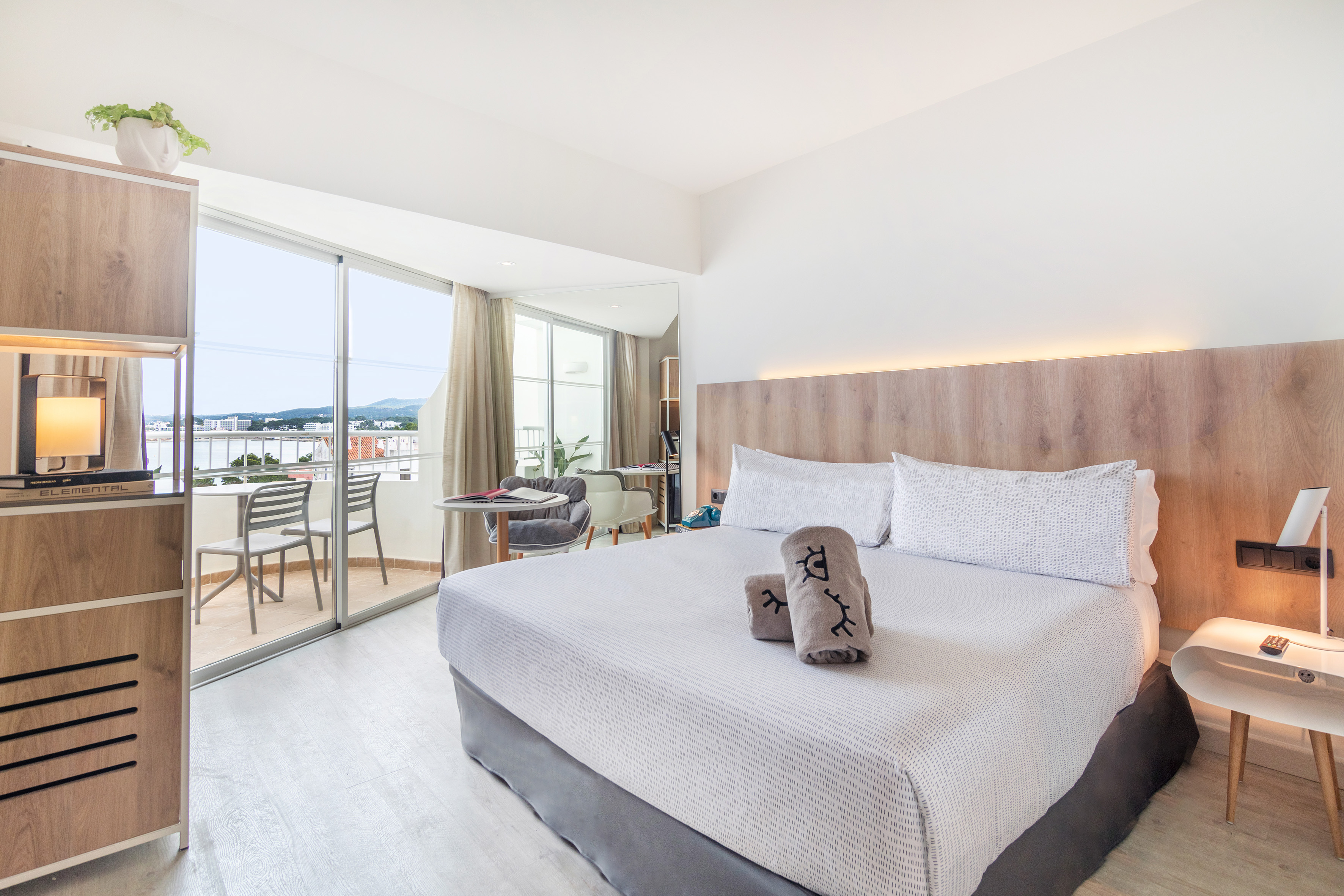 Modern hotel room with balcony and sea view.