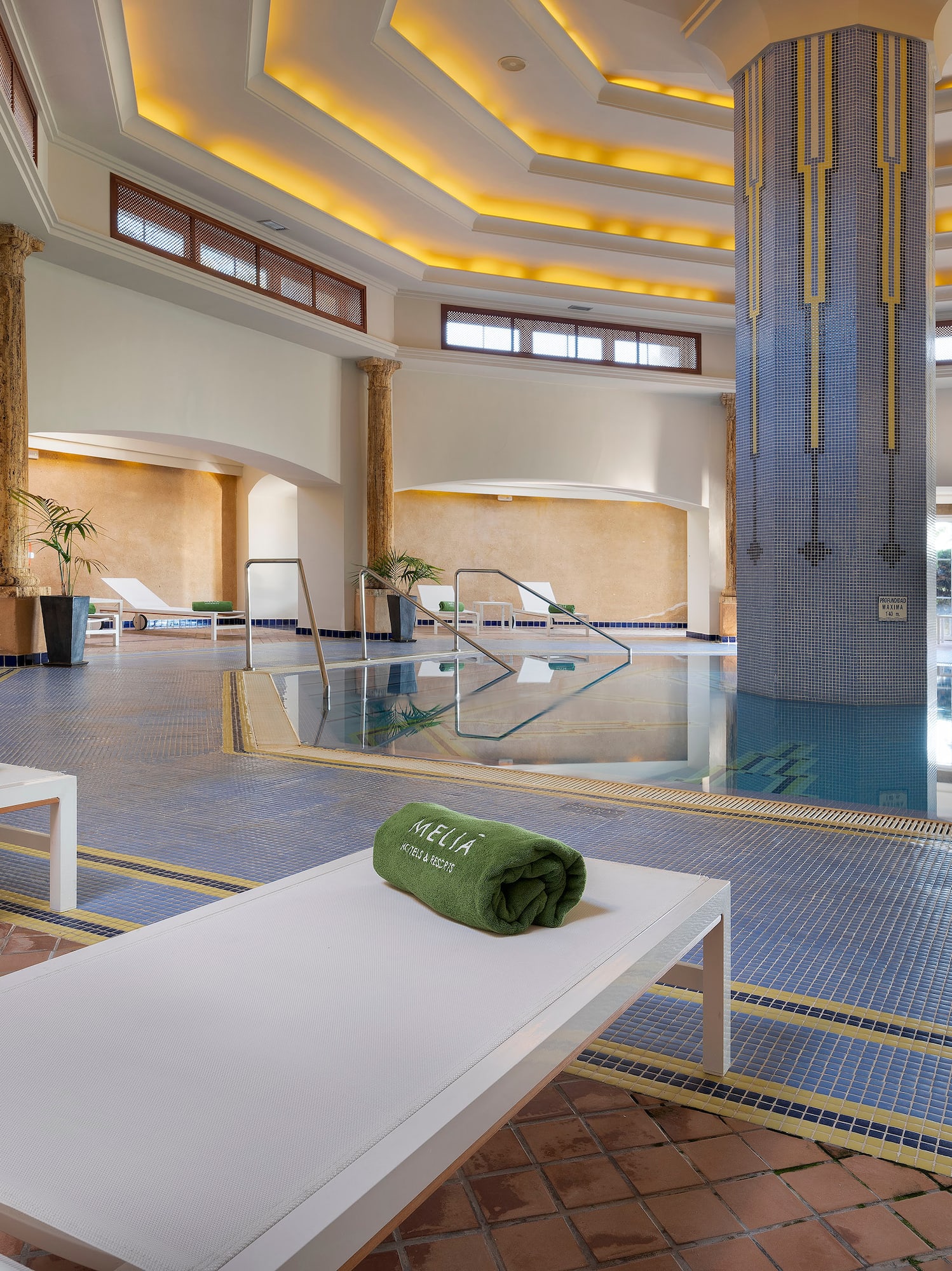 a pool with chairs and a large column