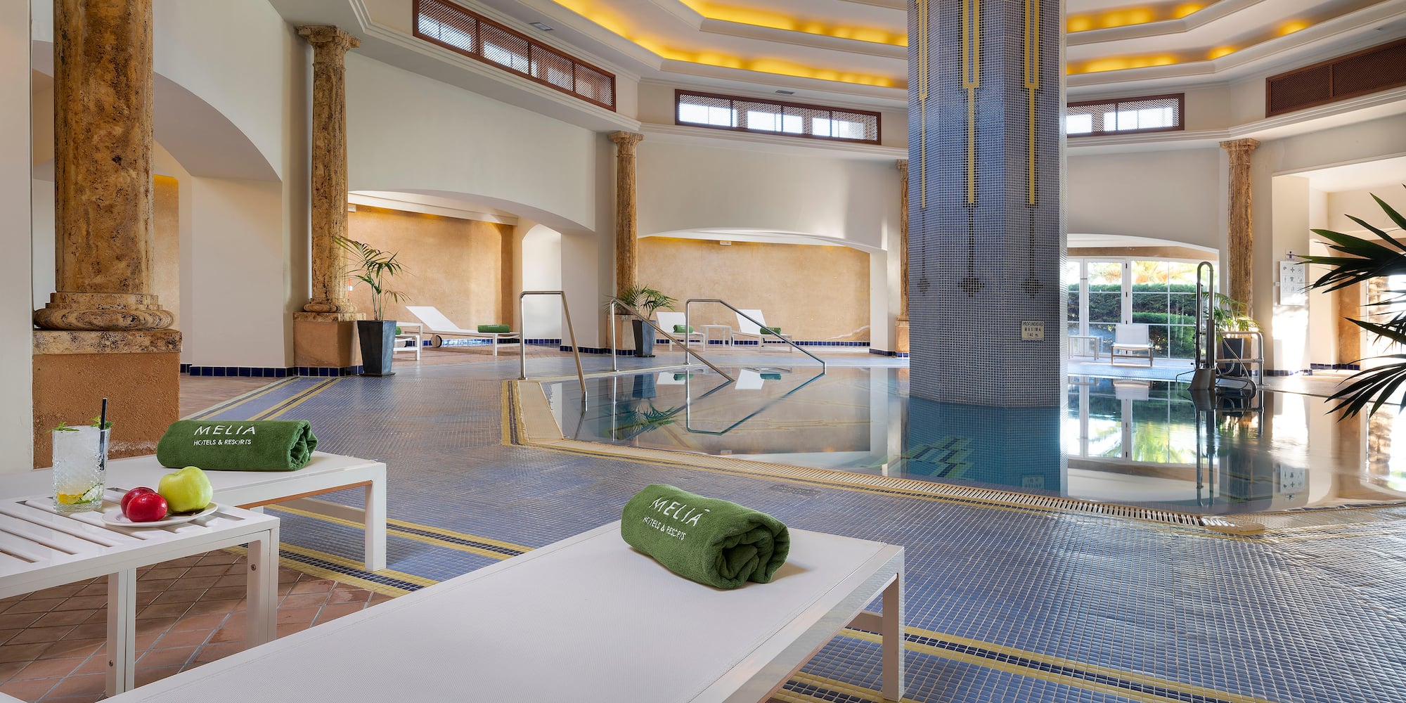 a pool with chairs and a large column