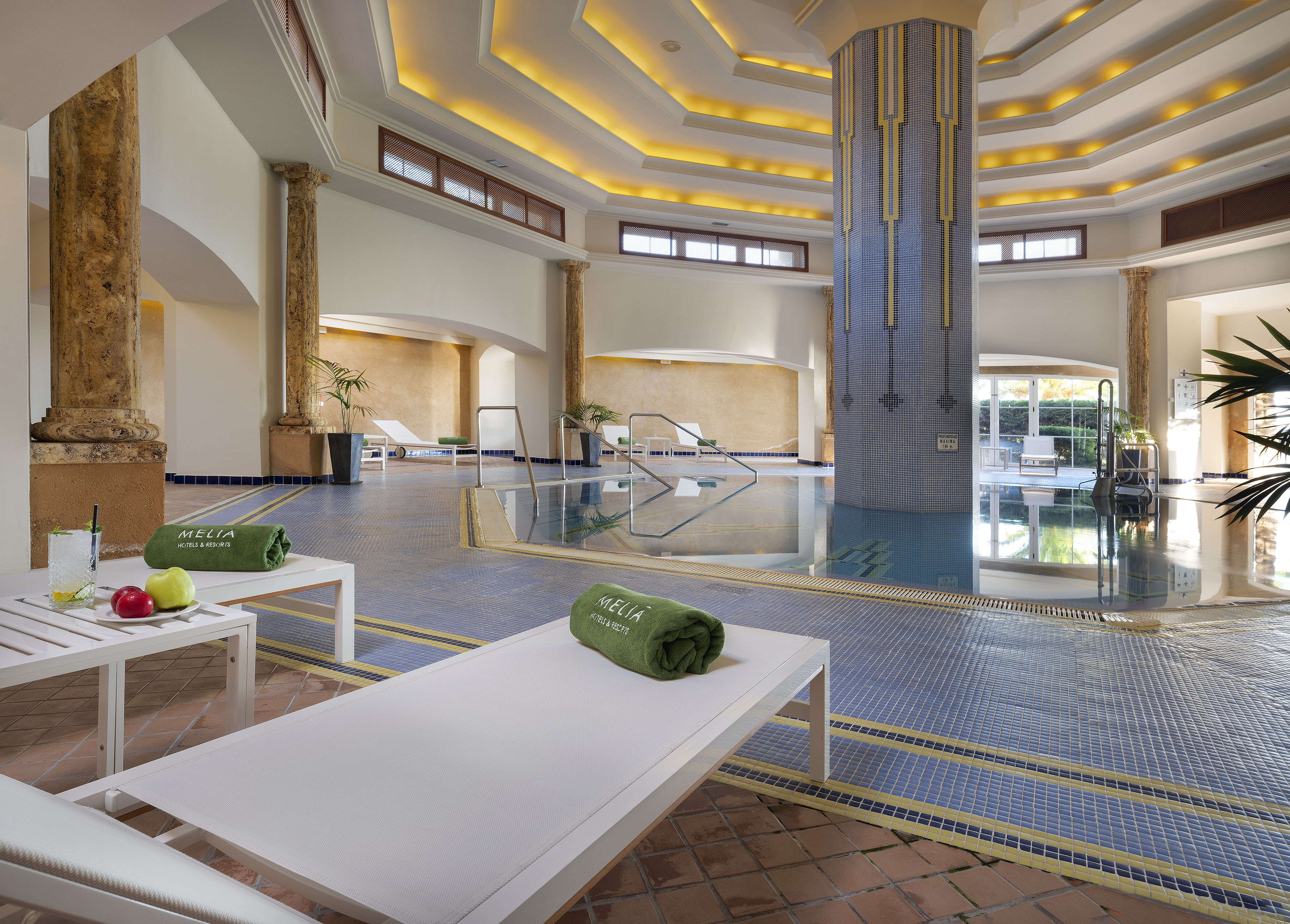 a pool with chairs and a large column