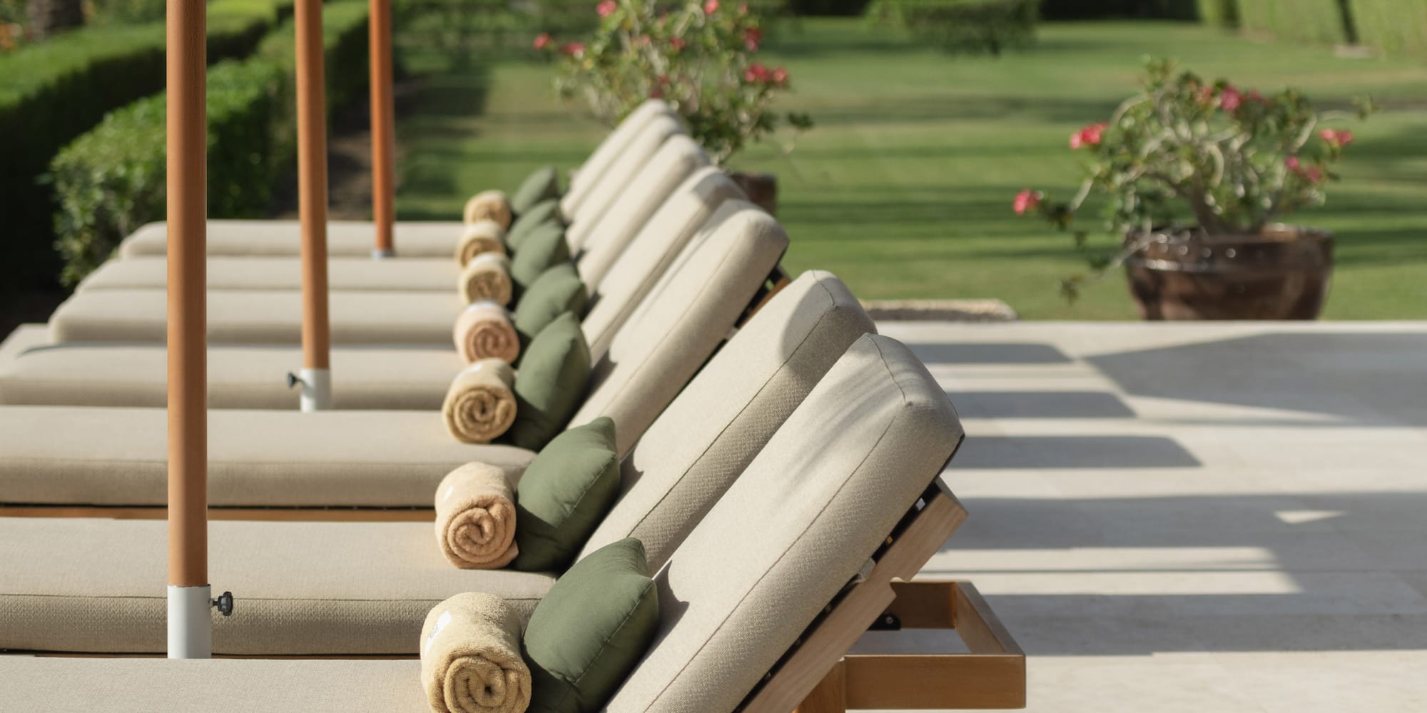 a row of lounge chairs with towels and umbrellas