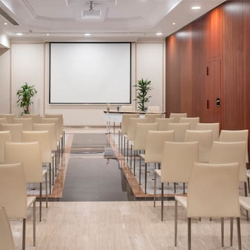 a room with chairs and a projector screen