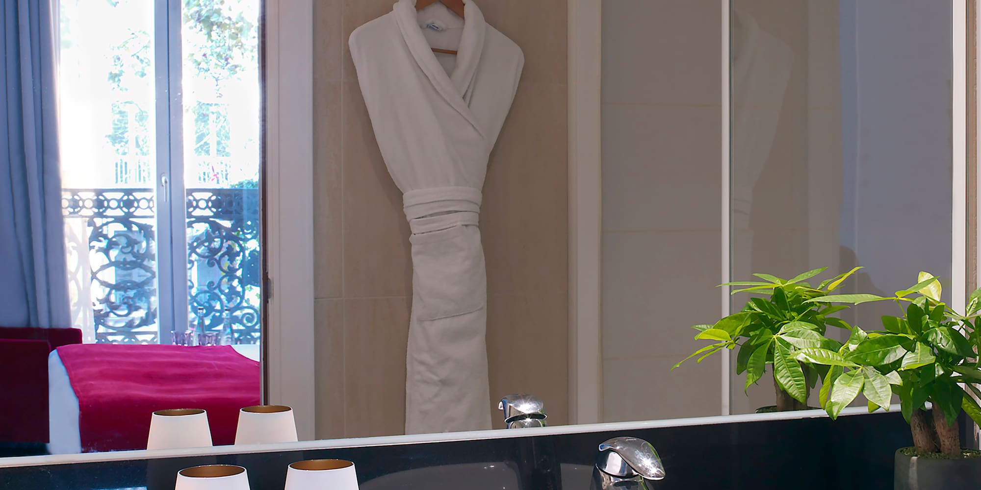 a bathroom with a black countertop sink and a white robe on the wall