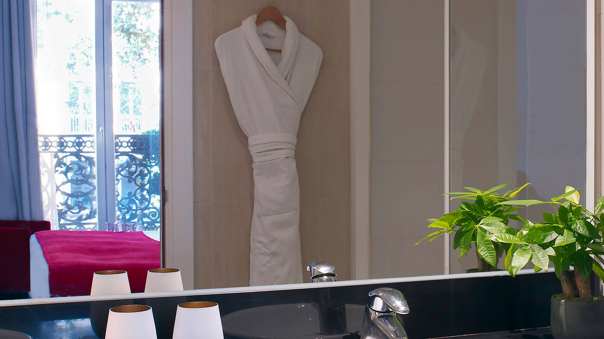a bathroom with a black countertop sink and a white robe on the wall