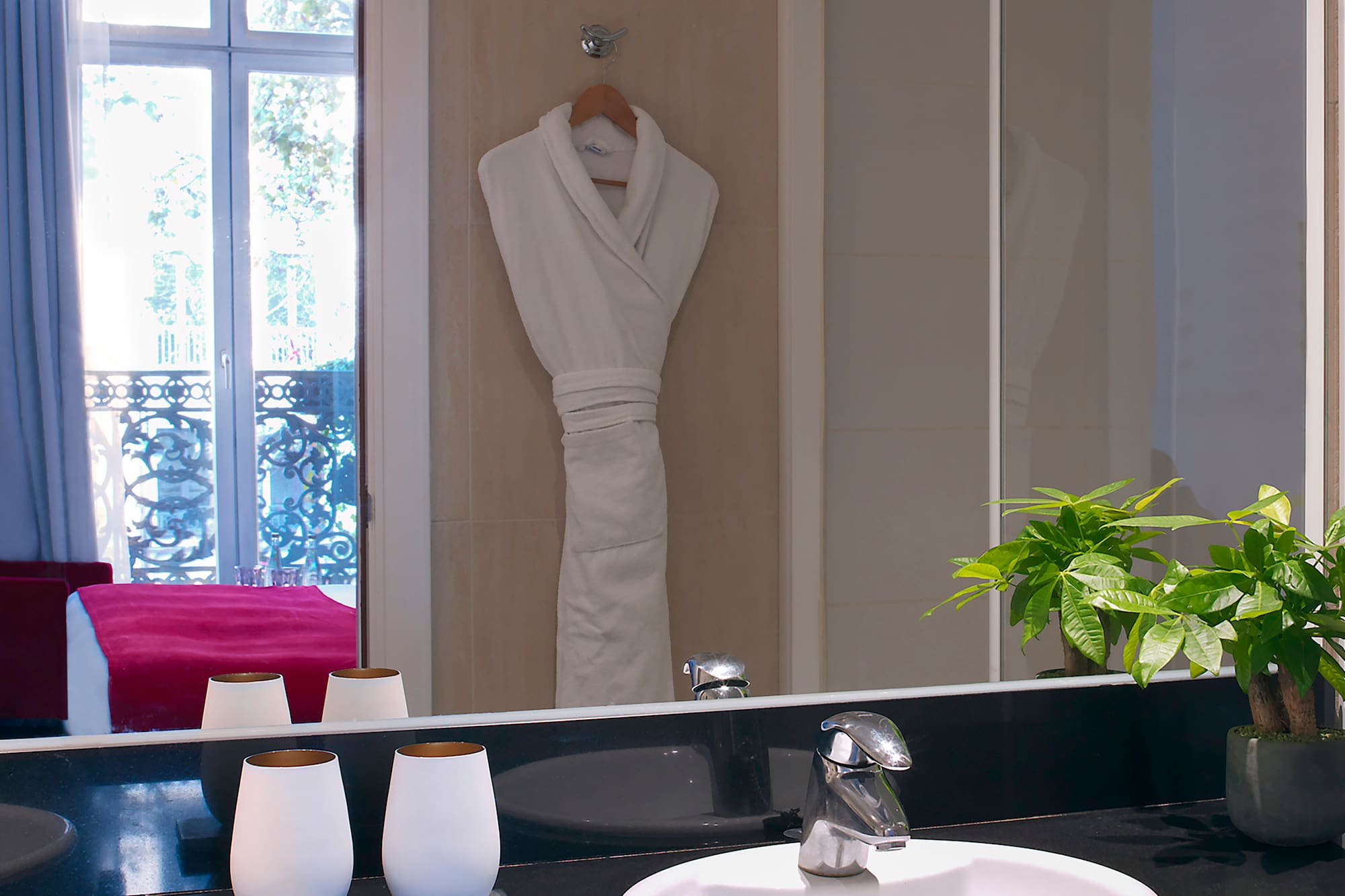 a bathroom with a black countertop sink and a white robe on the wall