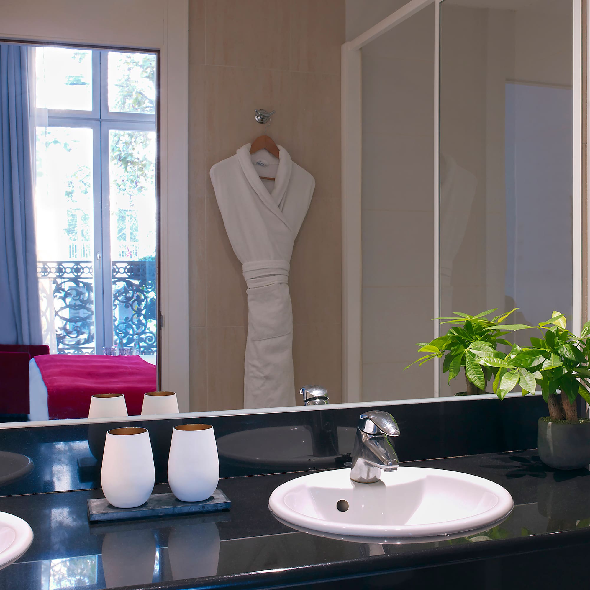 a bathroom with a black countertop sink and a white robe on the wall
