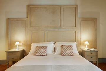 a bed with two lamps and a wall of wood panels