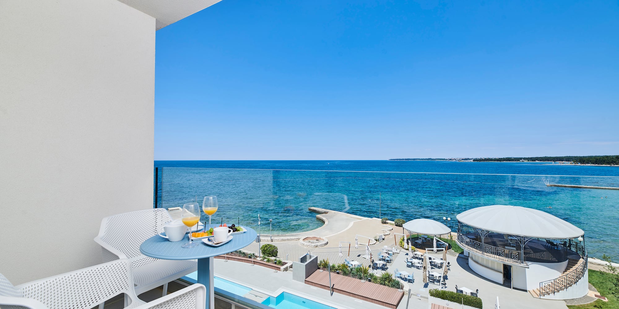a table and chairs with a view of the ocean