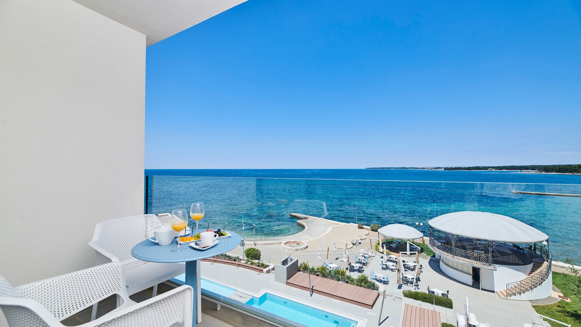 a table and chairs with a view of the ocean
