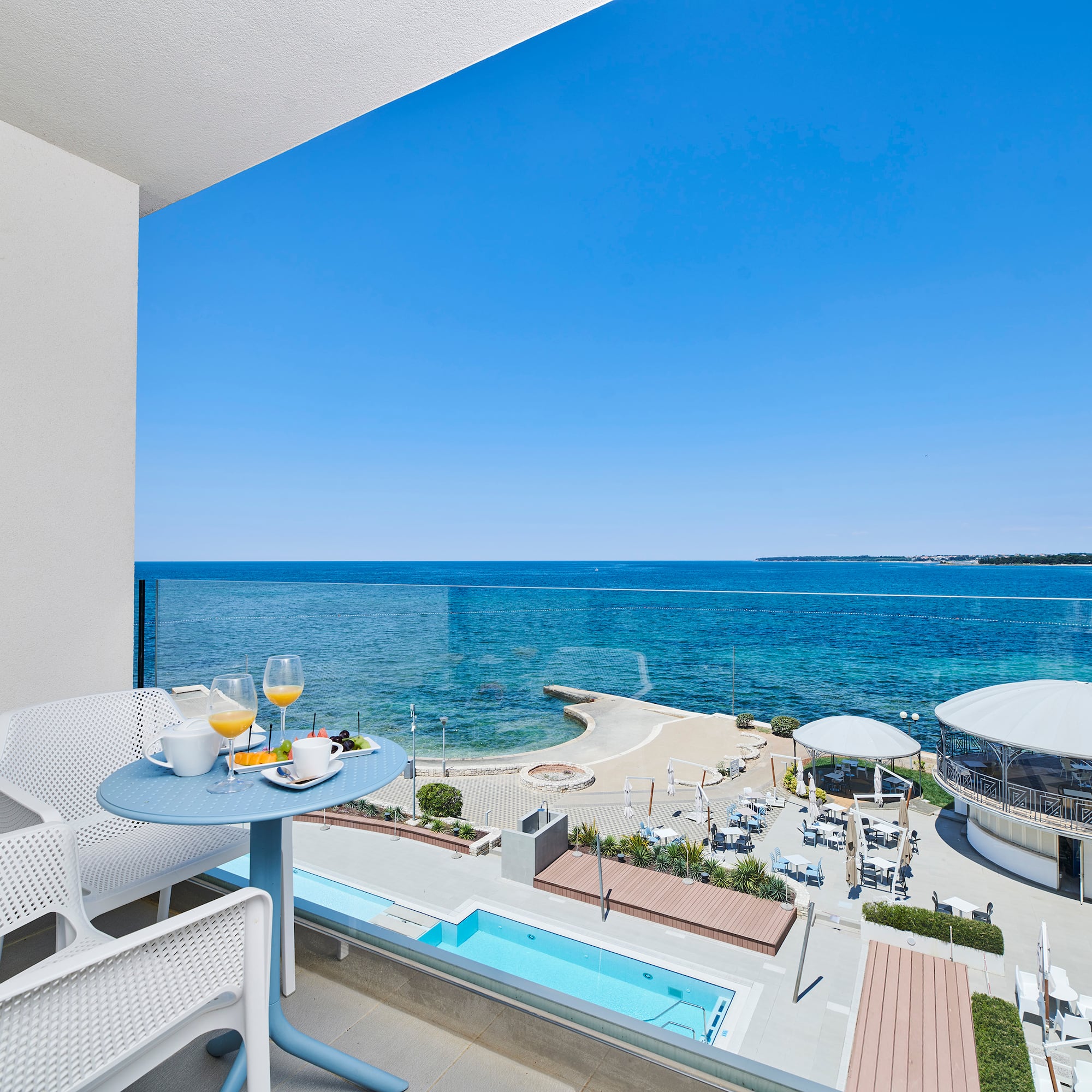 a table and chairs with a view of the ocean