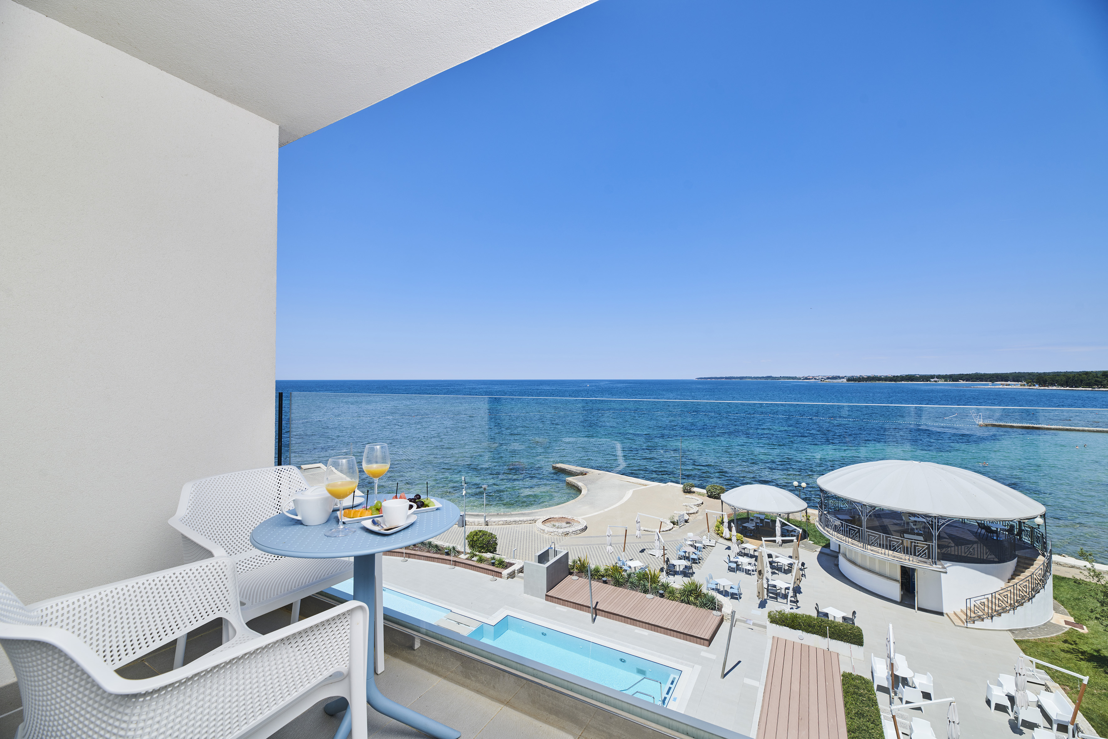 a table and chairs with a view of the ocean